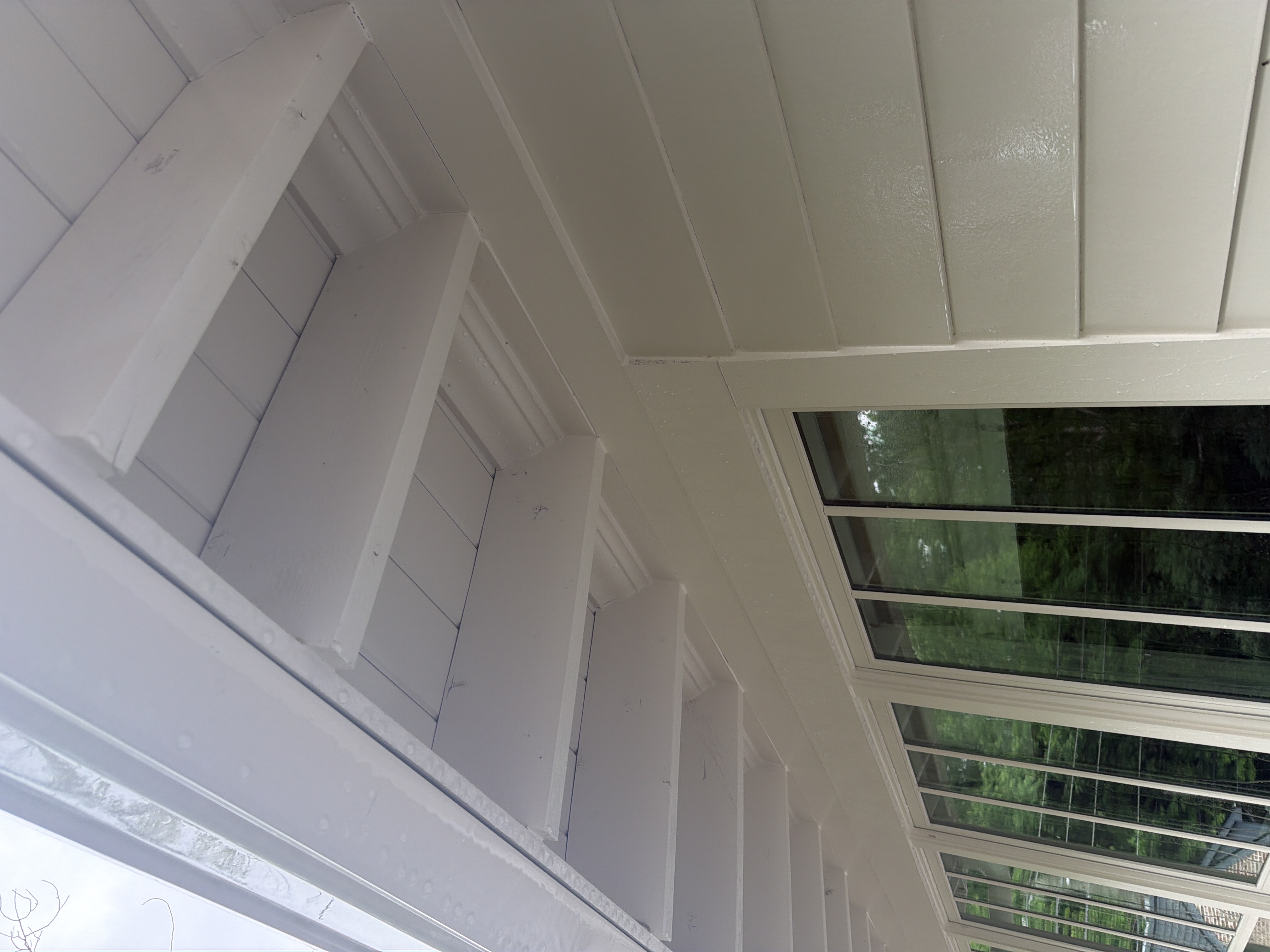 Clean white wood soffit and beam ceiling on enclosed porch after house washing in Marietta, GA