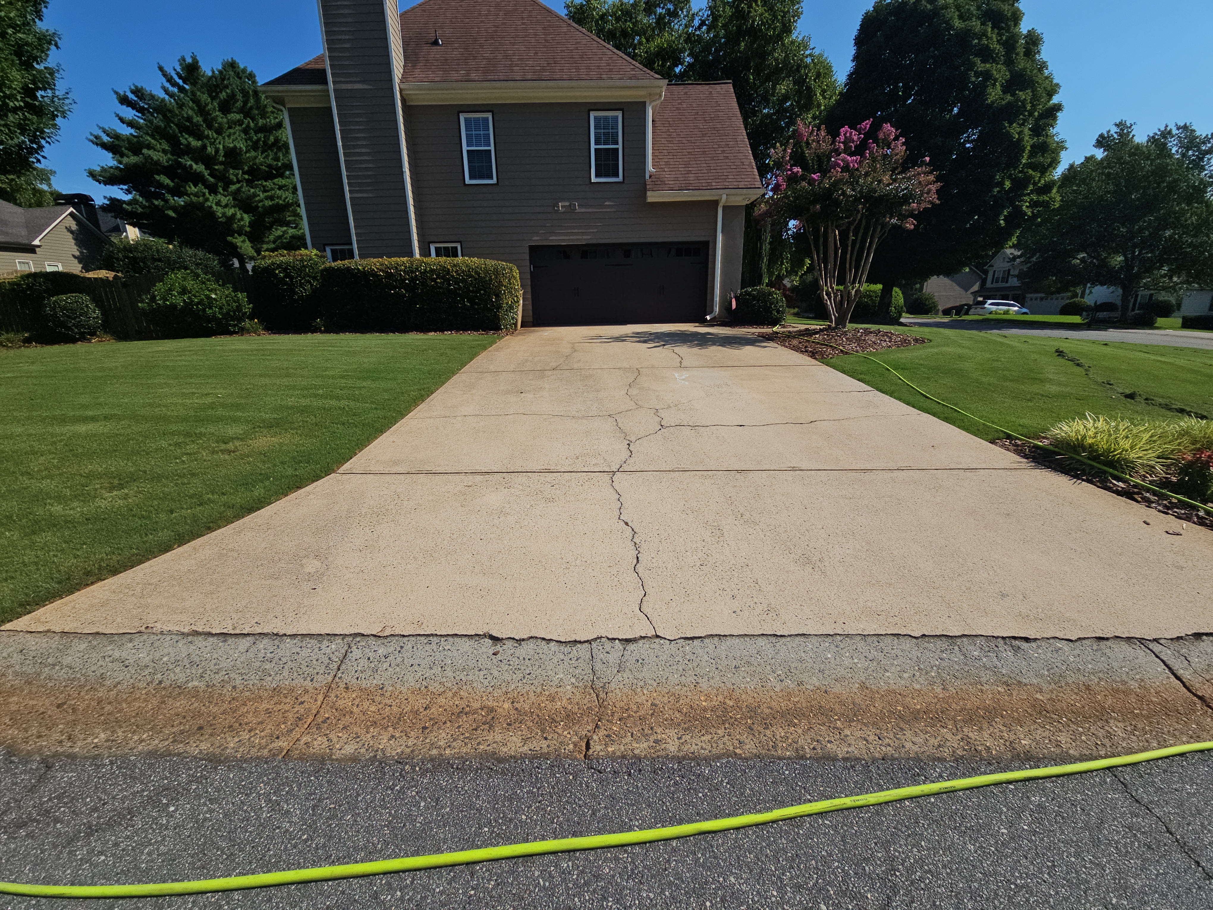 Wide concrete driveway at a residential home in Alpharetta, GA, viewed from the street during a pressure washing visit.