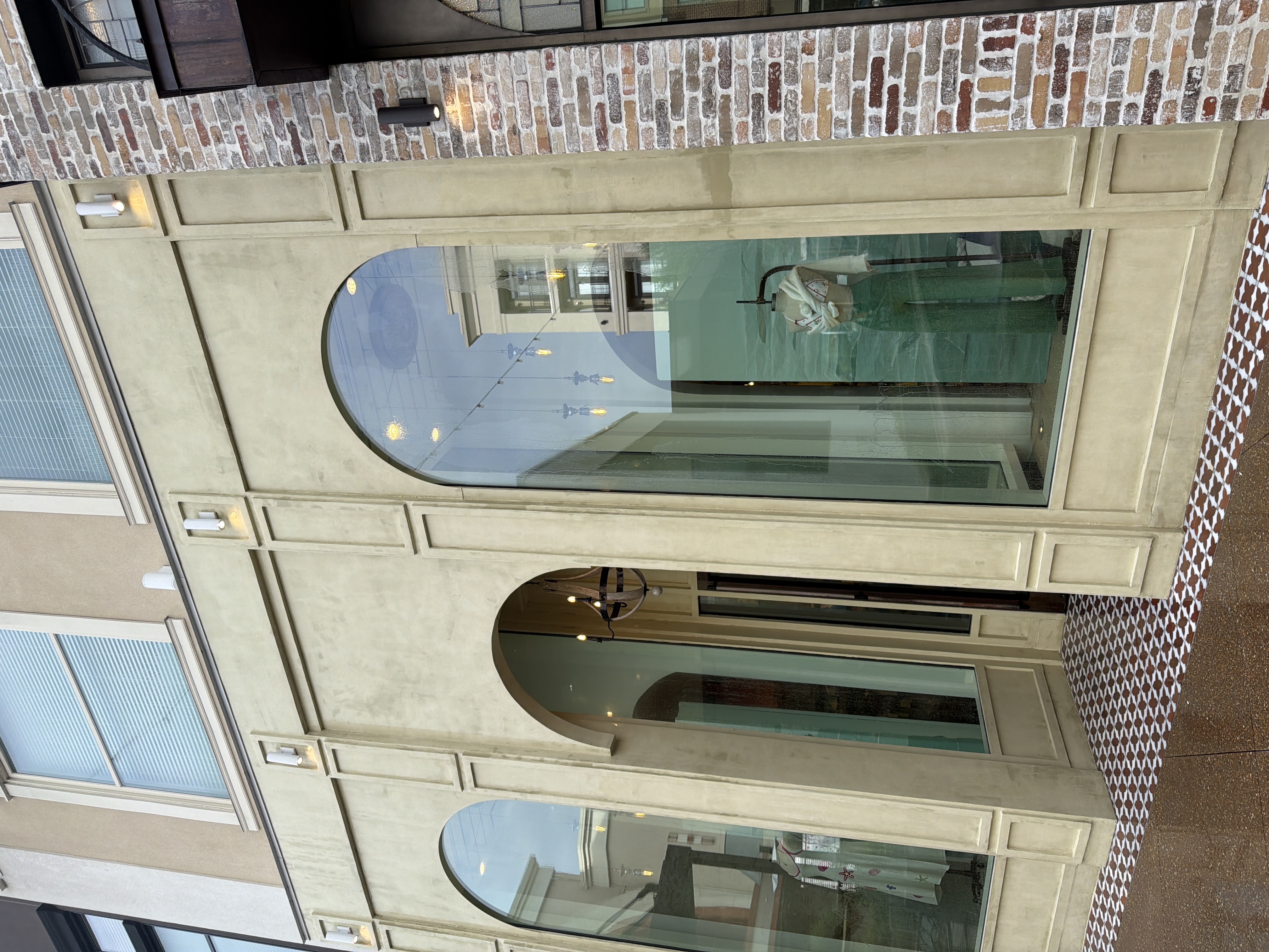 Full-width view of cleaned commercial retail storefront stucco facade and arched windows after building wash in Alpharetta, GA