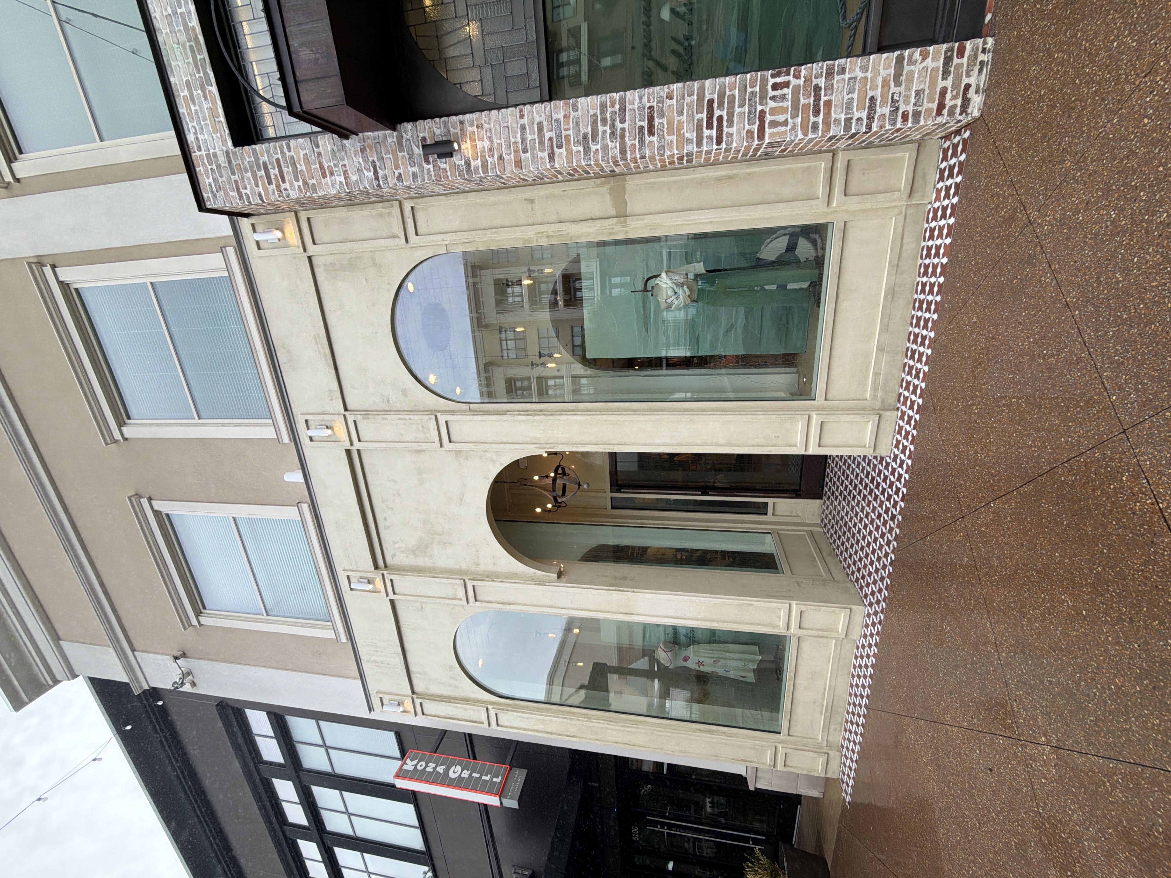 Wide after shot of pressure-washed stucco commercial building facade with two arched windows and entrance in Alpharetta, GA