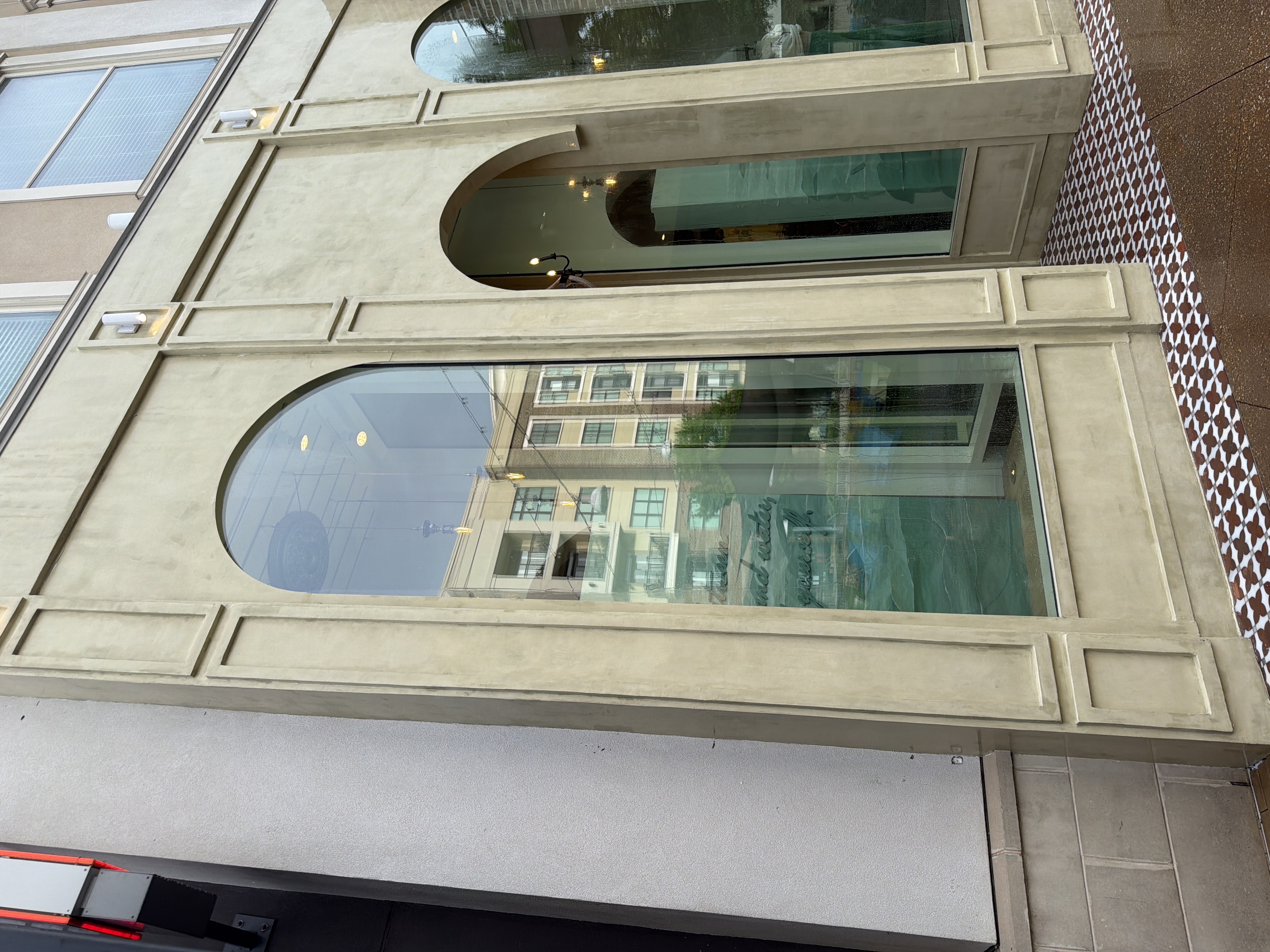 Left side of cleaned stucco commercial storefront with arched windows after building wash in Alpharetta, GA