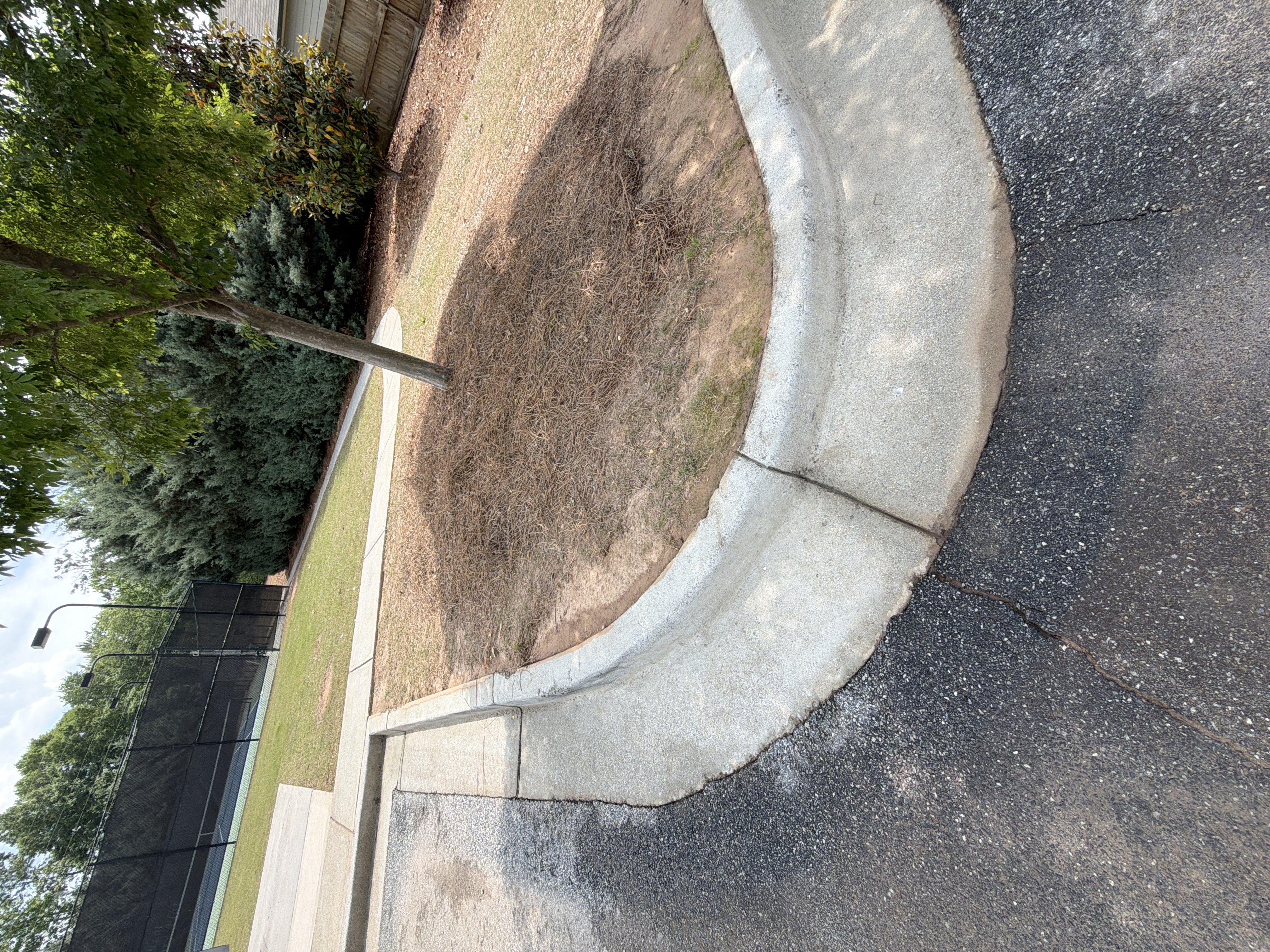 Clean concrete curb and parking island after pressure washing at a commercial property in Canton, GA