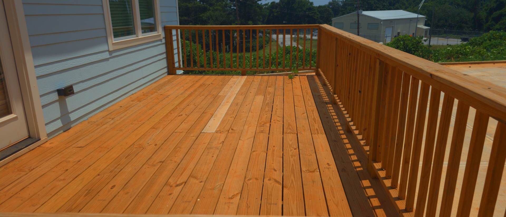 Wood deck with railing on a new construction home at a pressure washing job in Atlanta, GA.