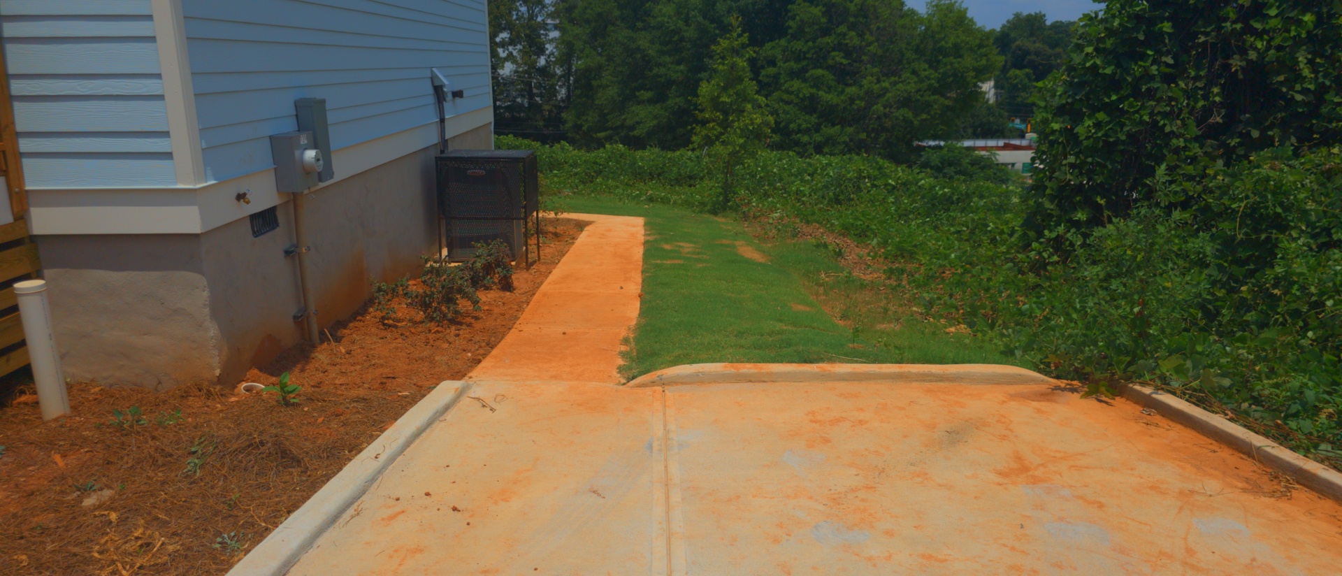 Concrete side path running alongside a new construction home at a pressure washing job in Atlanta, GA.