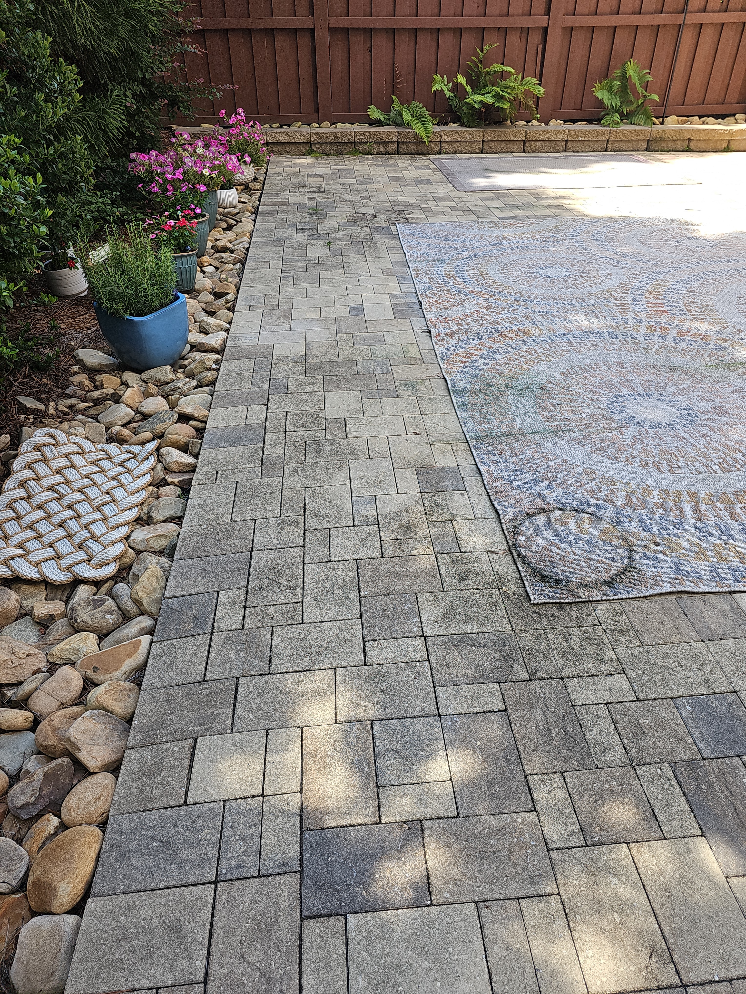 Stone paver path with visible grime and organic buildup beside an outdoor rug at a Marietta, GA home.