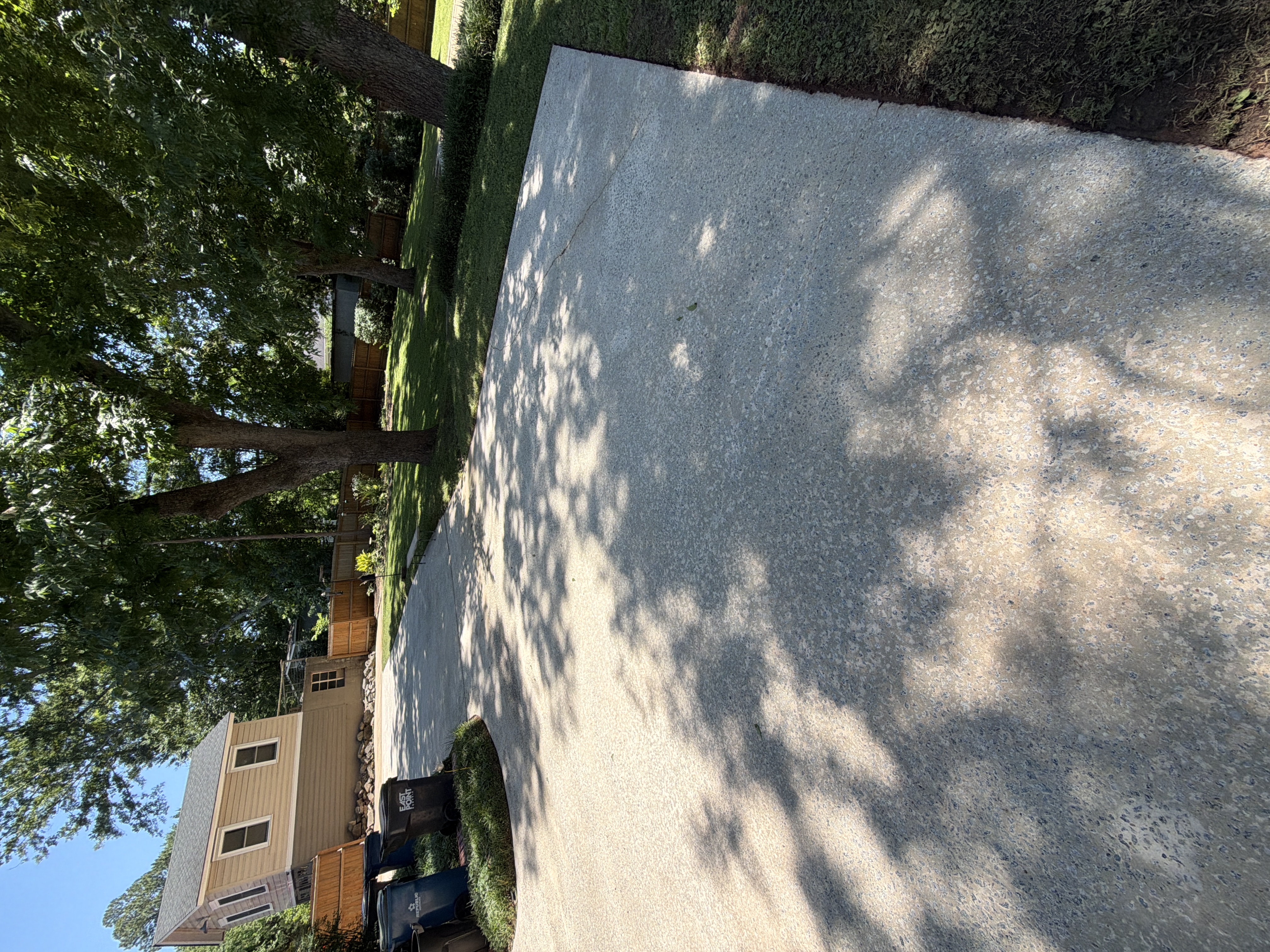 Wide concrete driveway pad freshly pressure washed and clean in the sun in East Point, GA