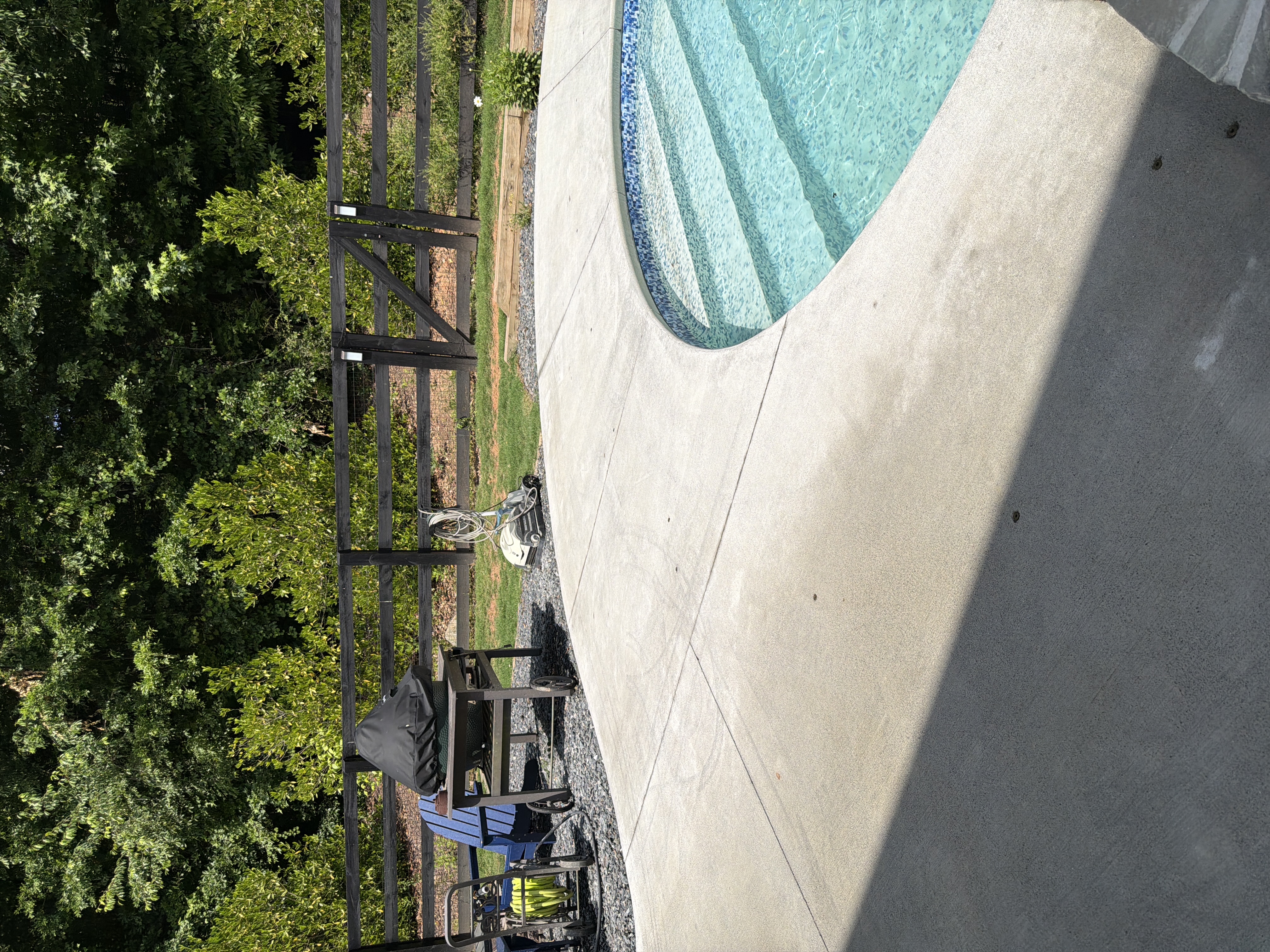 Concrete pool deck after cleaning in Canton, GA. A lot of the red Georgian clay staining was lifted from the surface, revealing the true concrete color hidden beneath.