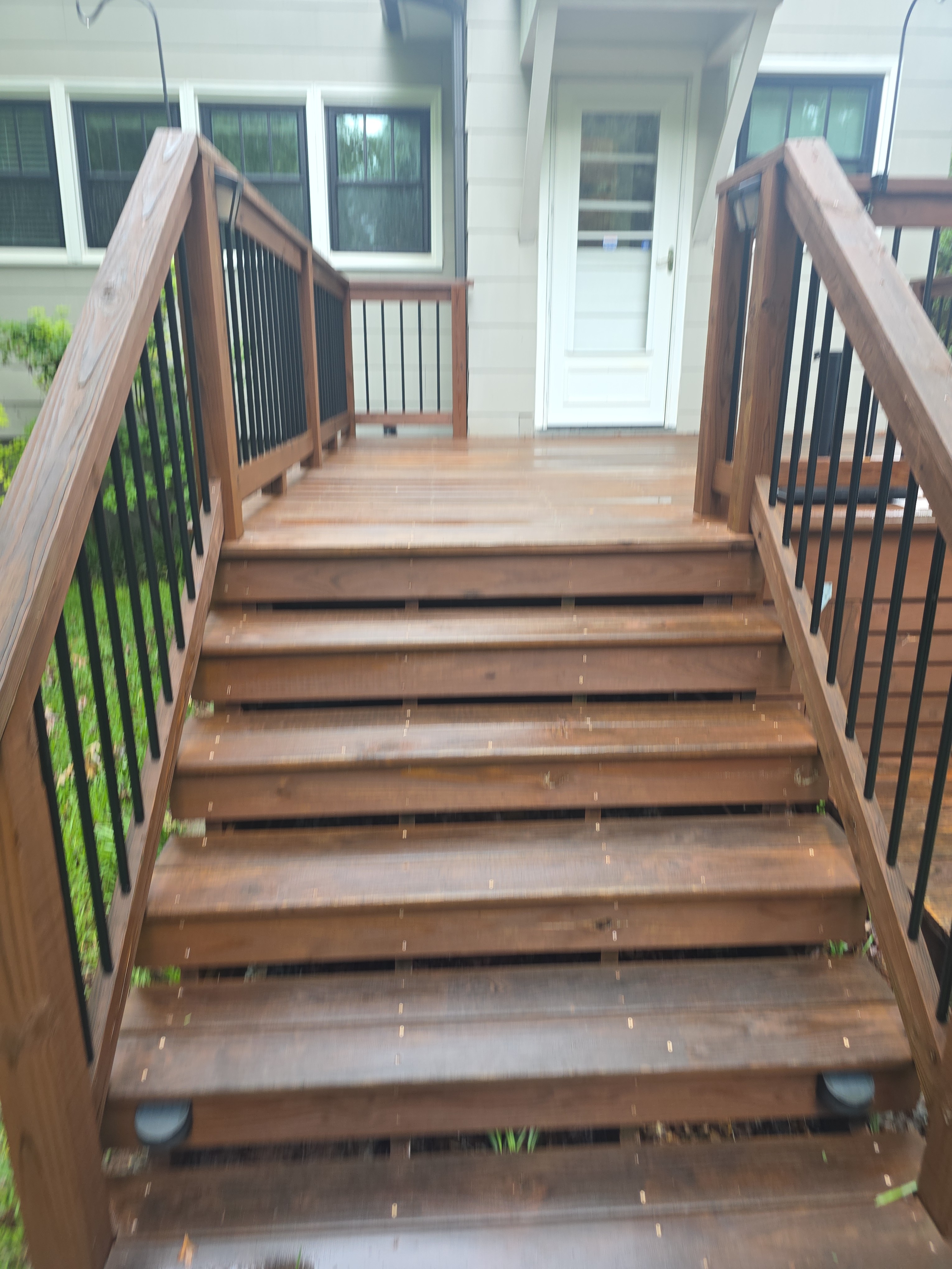 Stunning before-after of wood deck staircase leading up to house entry after Alpha Pressure Washing service in East Point, GA