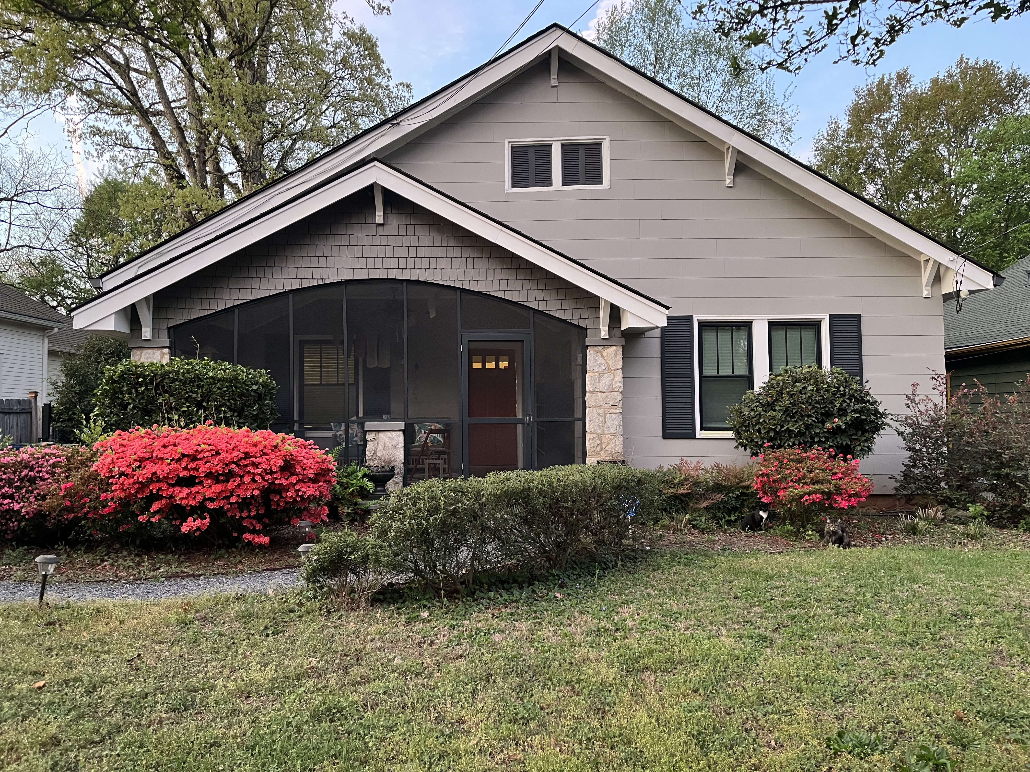 Craftsman bungalow with gray siding and screened porch before house washing service in East Point, GA