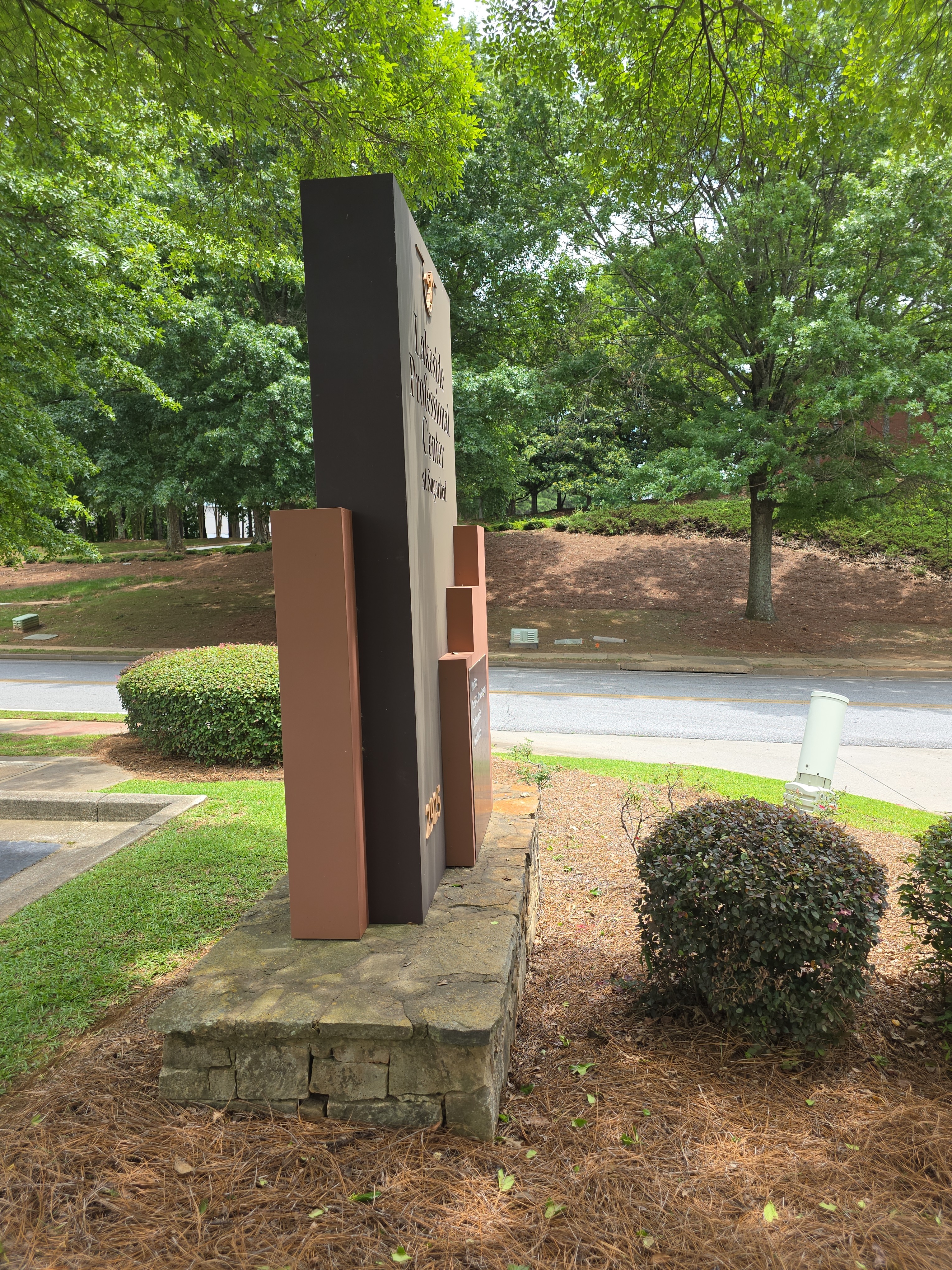 Side-angle view of a commercial monument sign on a stone base after soft washing in Duluth, GA.