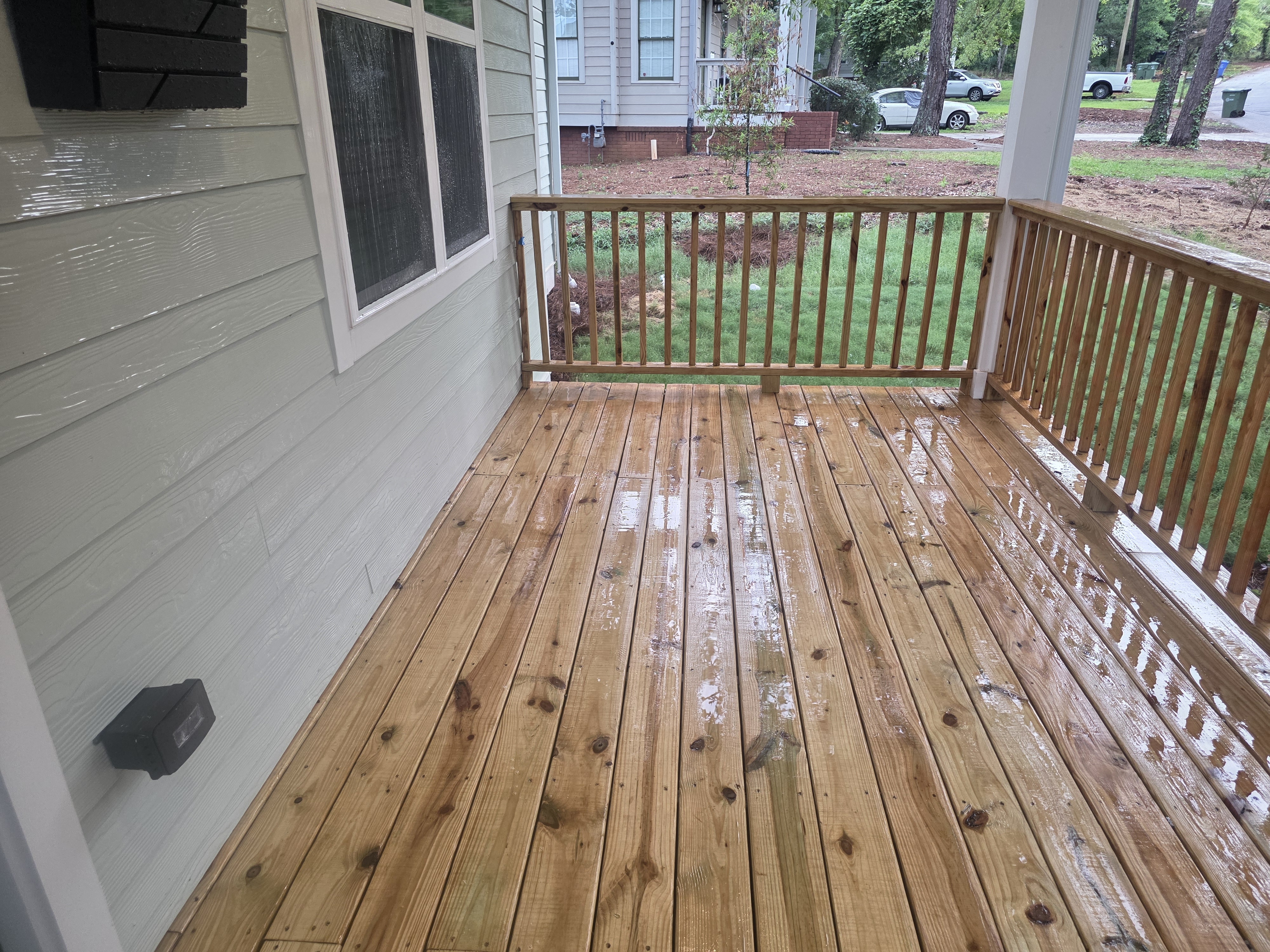 Wood porch deck and railing on a new construction home after pressure washing in Atlanta, GA.