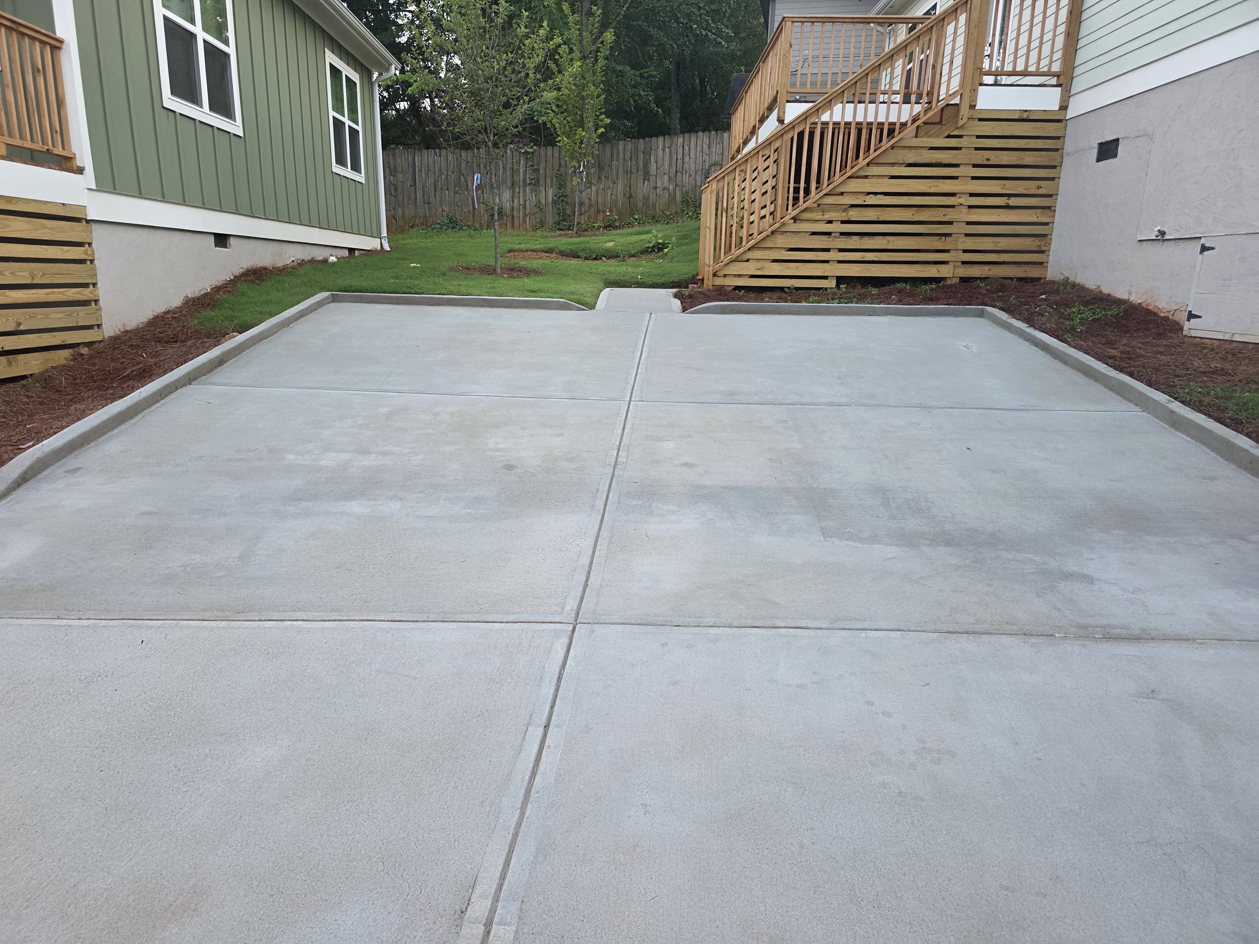 Wide concrete driveway pad between new construction homes after pressure washing in Atlanta, GA.