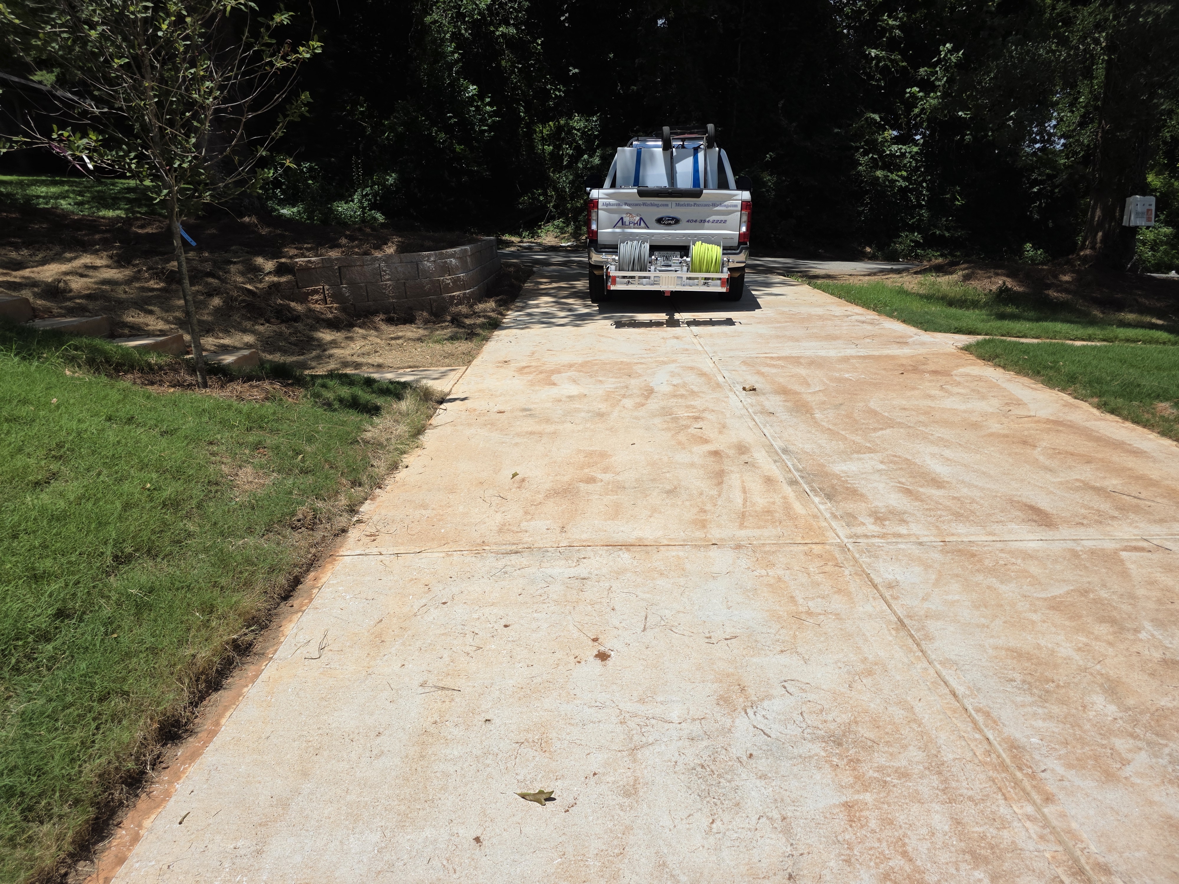 Alpha Pressure Washing truck and trailer on a concrete driveway at a new construction wash job in Atlanta, GA.