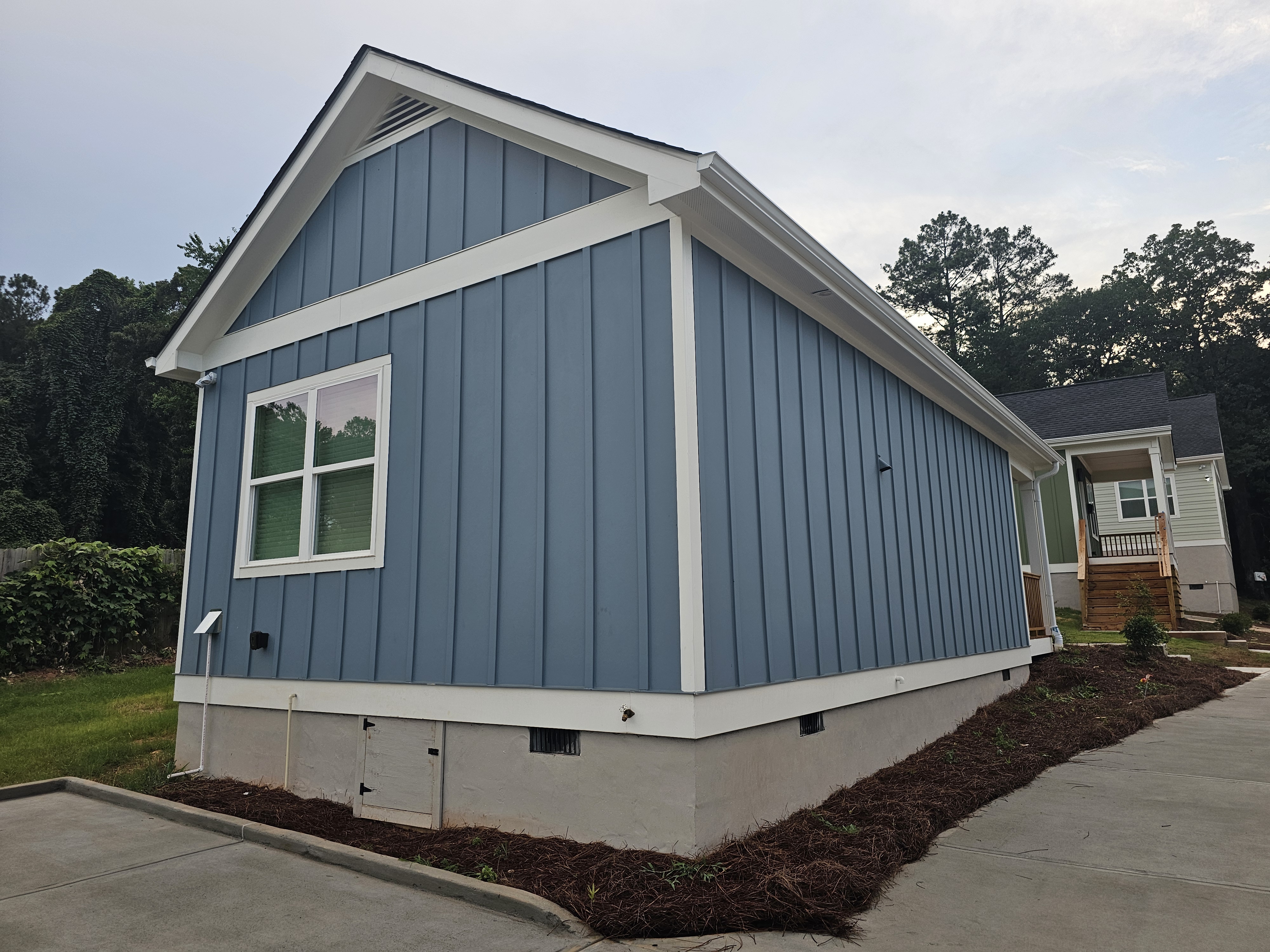 Gable end of a new construction home with blue board-and-batten siding at a house wash job in Atlanta, GA.