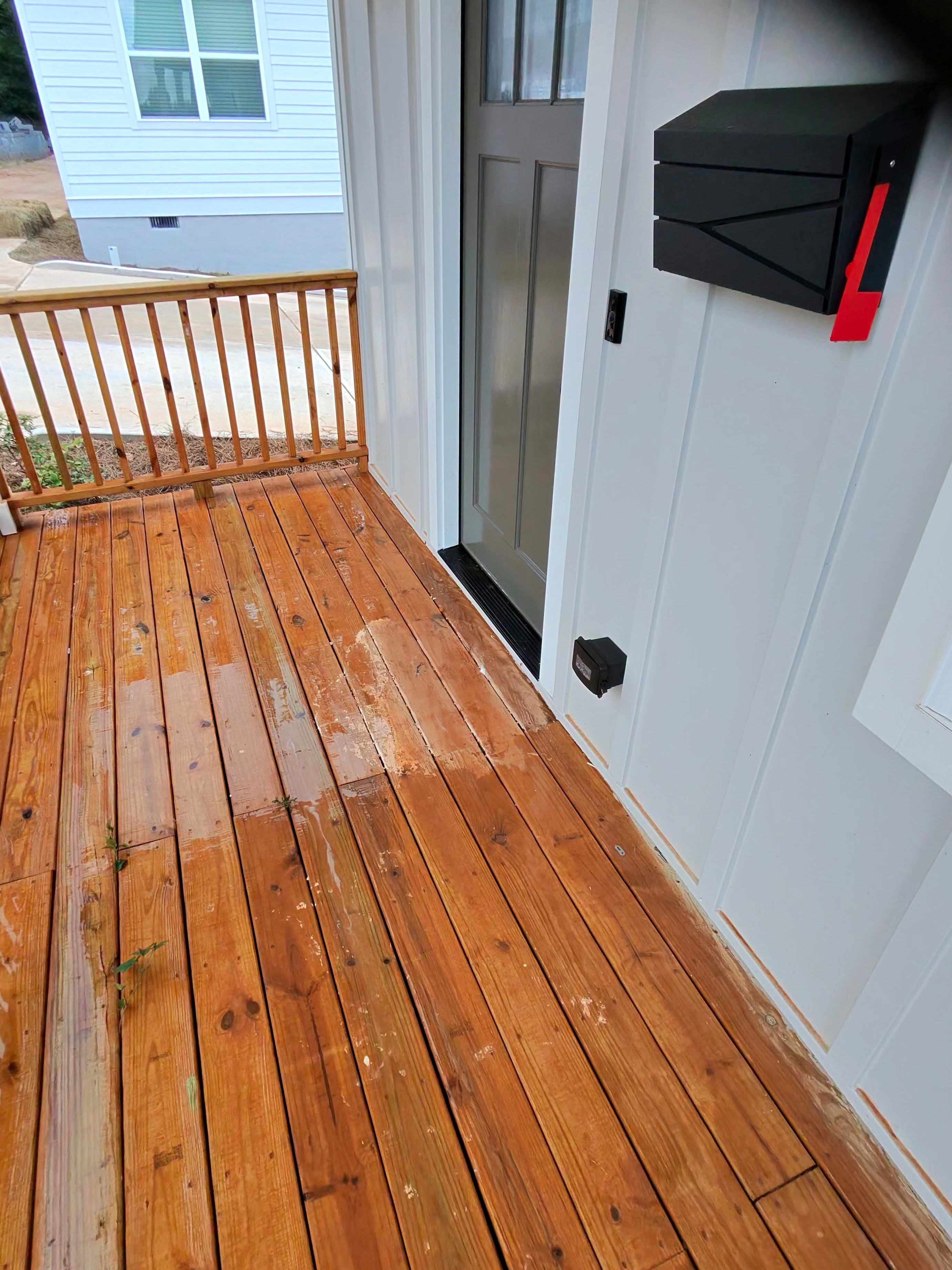 Wet wood porch deck boards with construction debris visible during a new construction wash in Atlanta, GA.
