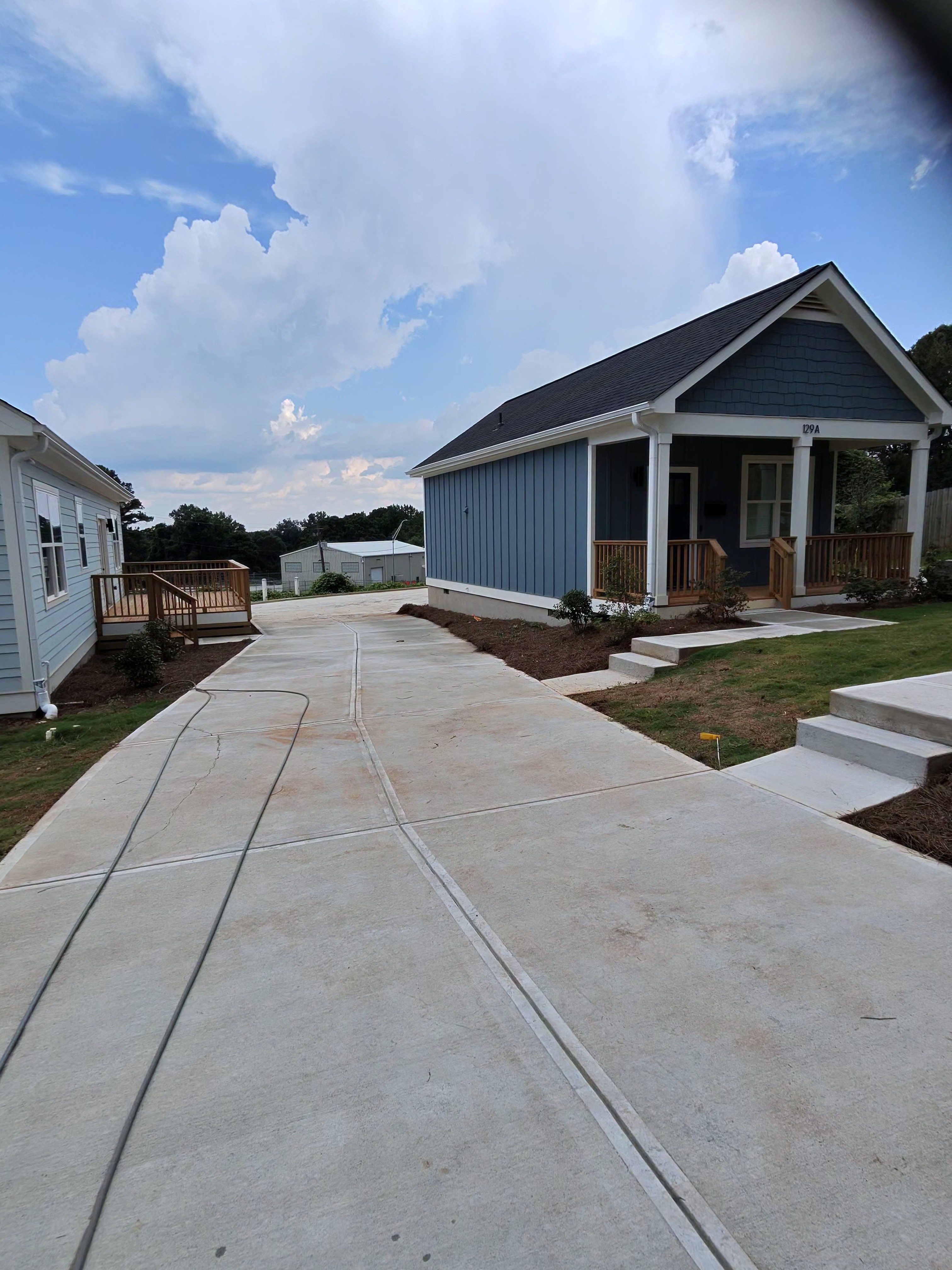New construction home with blue board-and-batten siding and wood porch deck at a pressure washing job in Atlanta, GA.