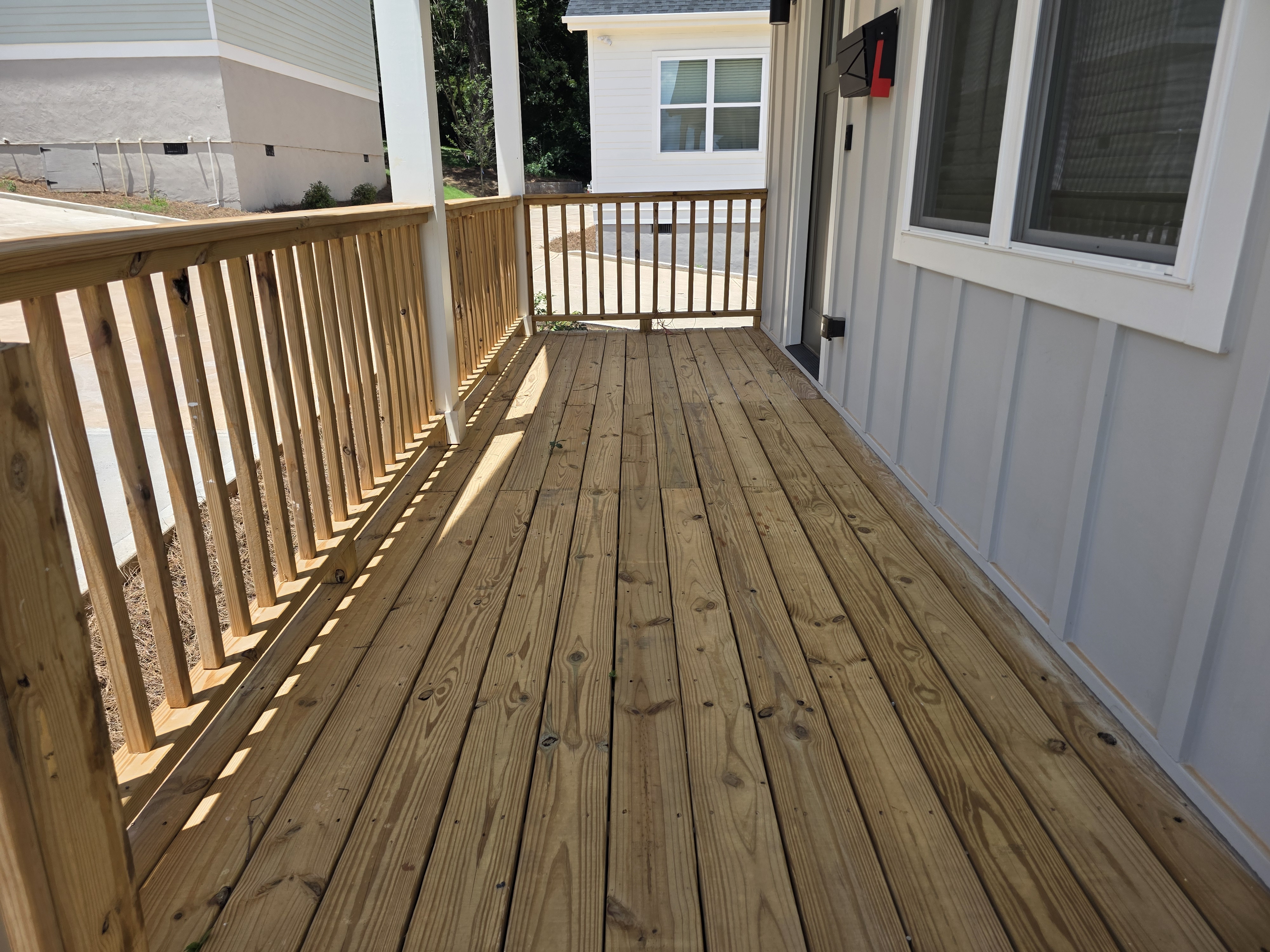 Wood porch deck with spindle railing on a new construction home after pressure washing in Atlanta, GA.