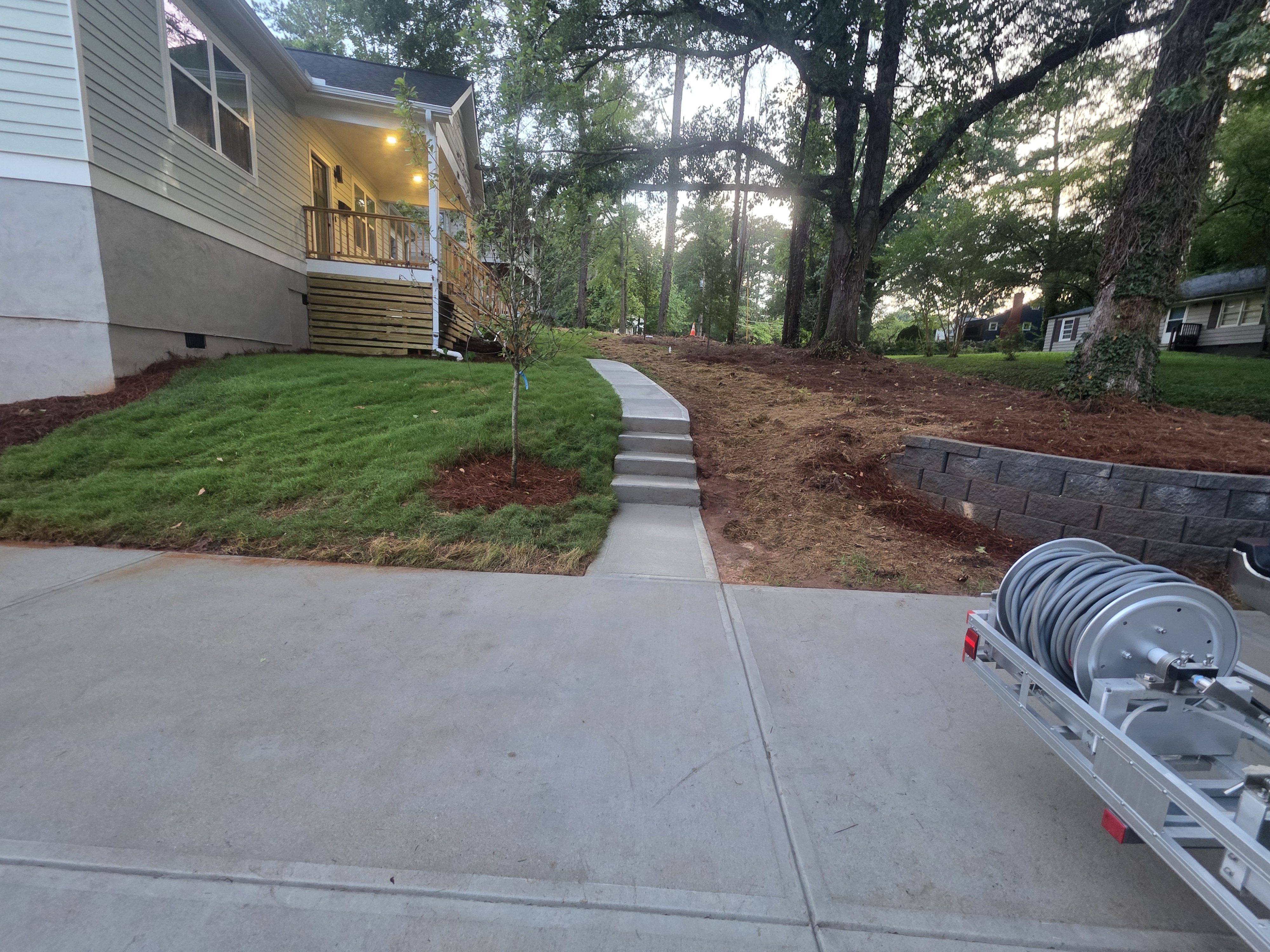Concrete walkway and steps leading from a driveway to a new construction home at dusk after a pressure washing job in Atlanta, GA.