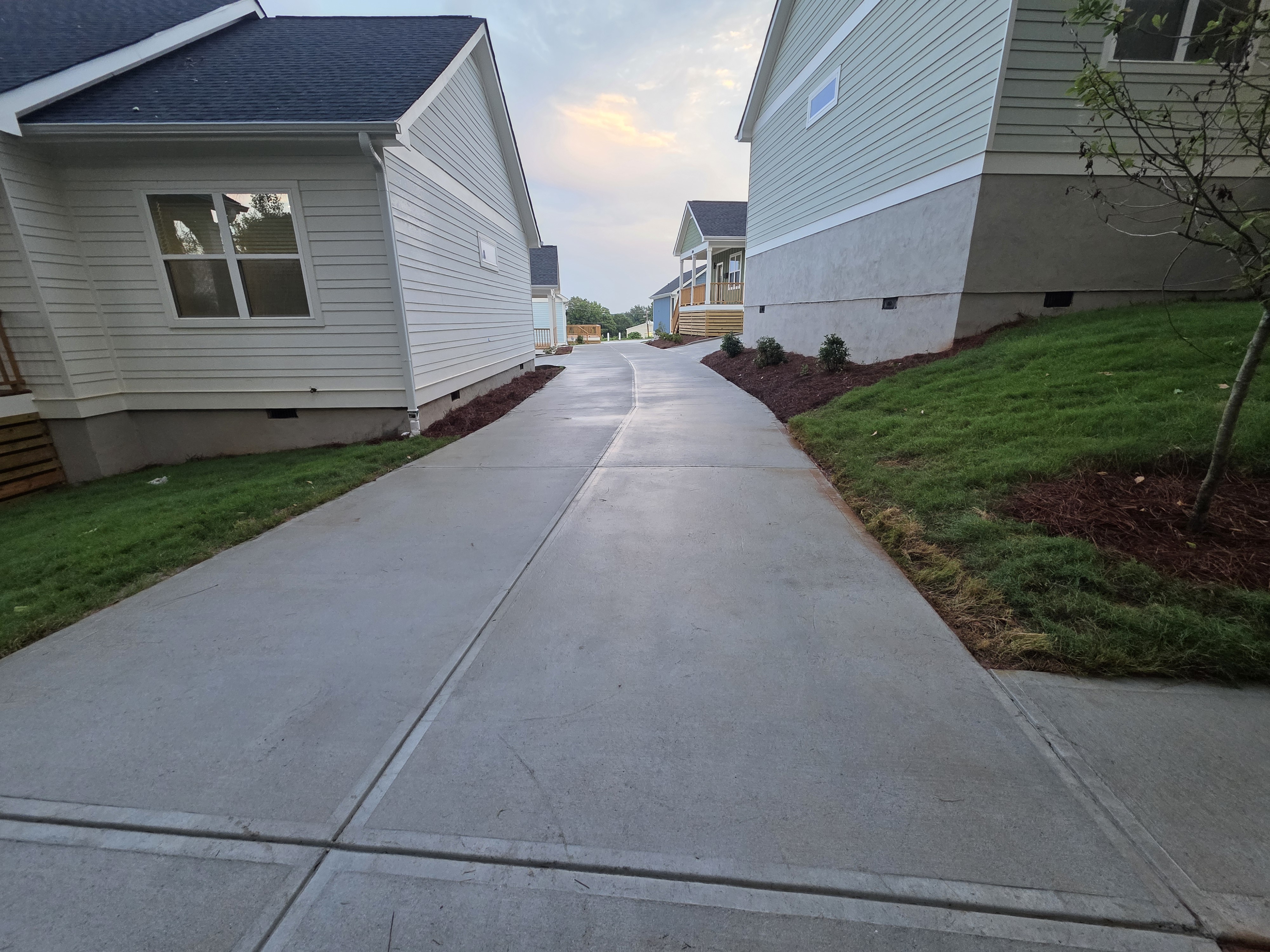 Concrete driveway between multiple new construction homes after pressure washing in Atlanta, GA.