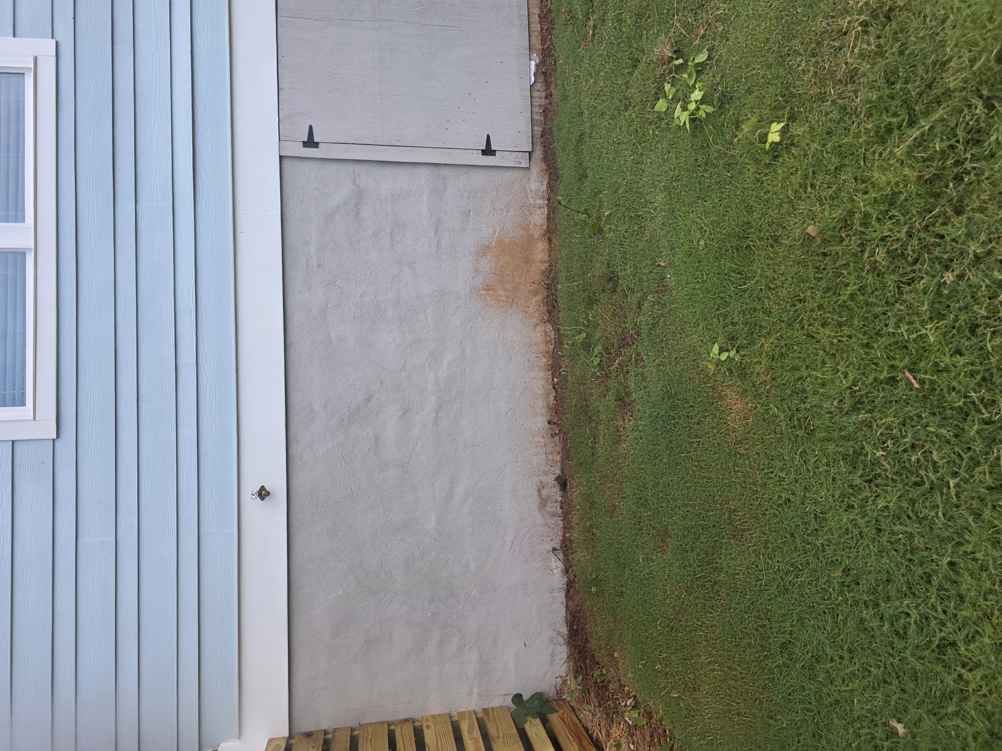 Concrete block foundation wall with rust staining below vinyl siding on a new construction home in Atlanta, GA.