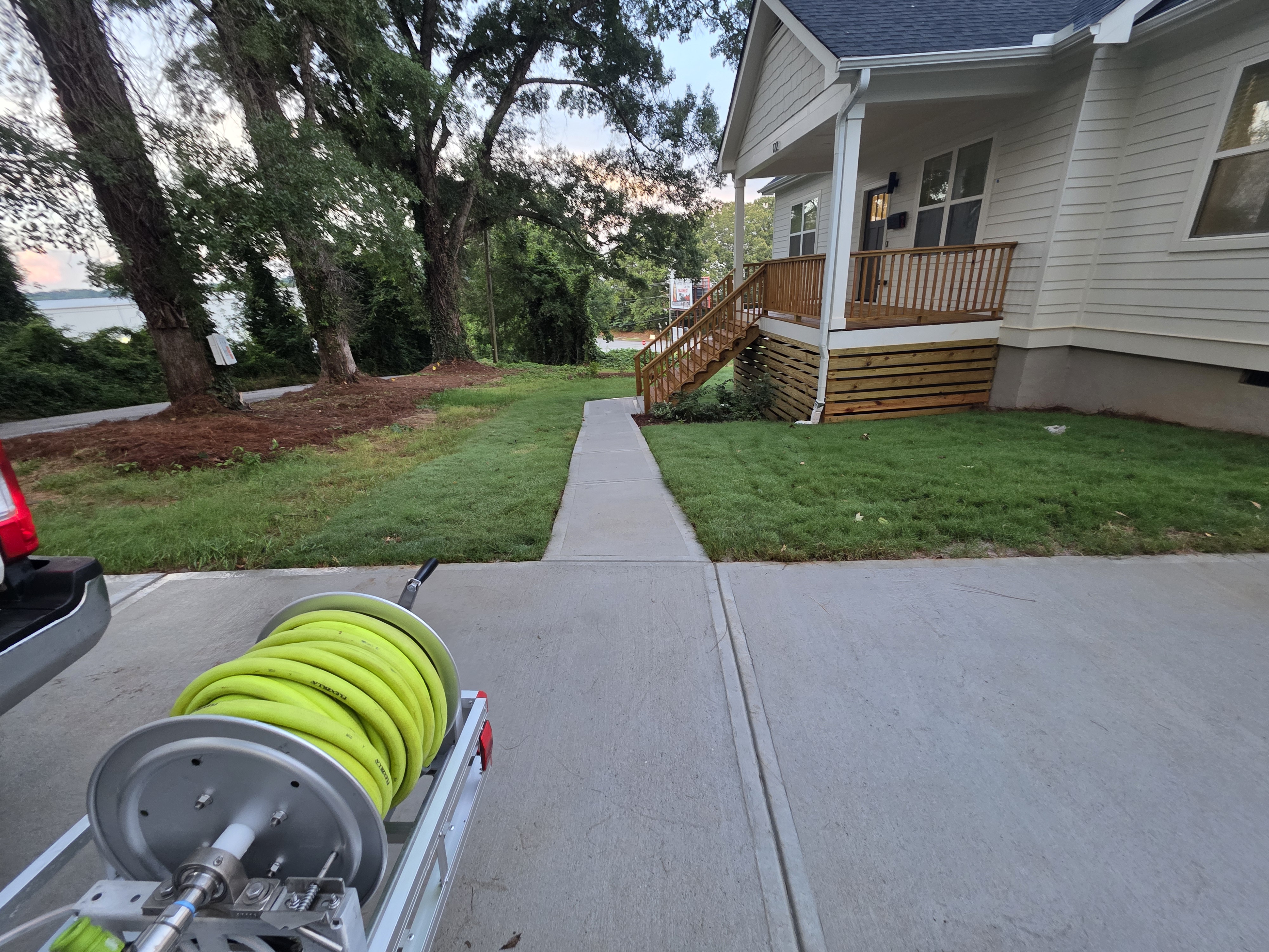 Alpha Pressure Washing hose reel trailer beside a concrete driveway and walkway at a new construction job in Atlanta, GA.