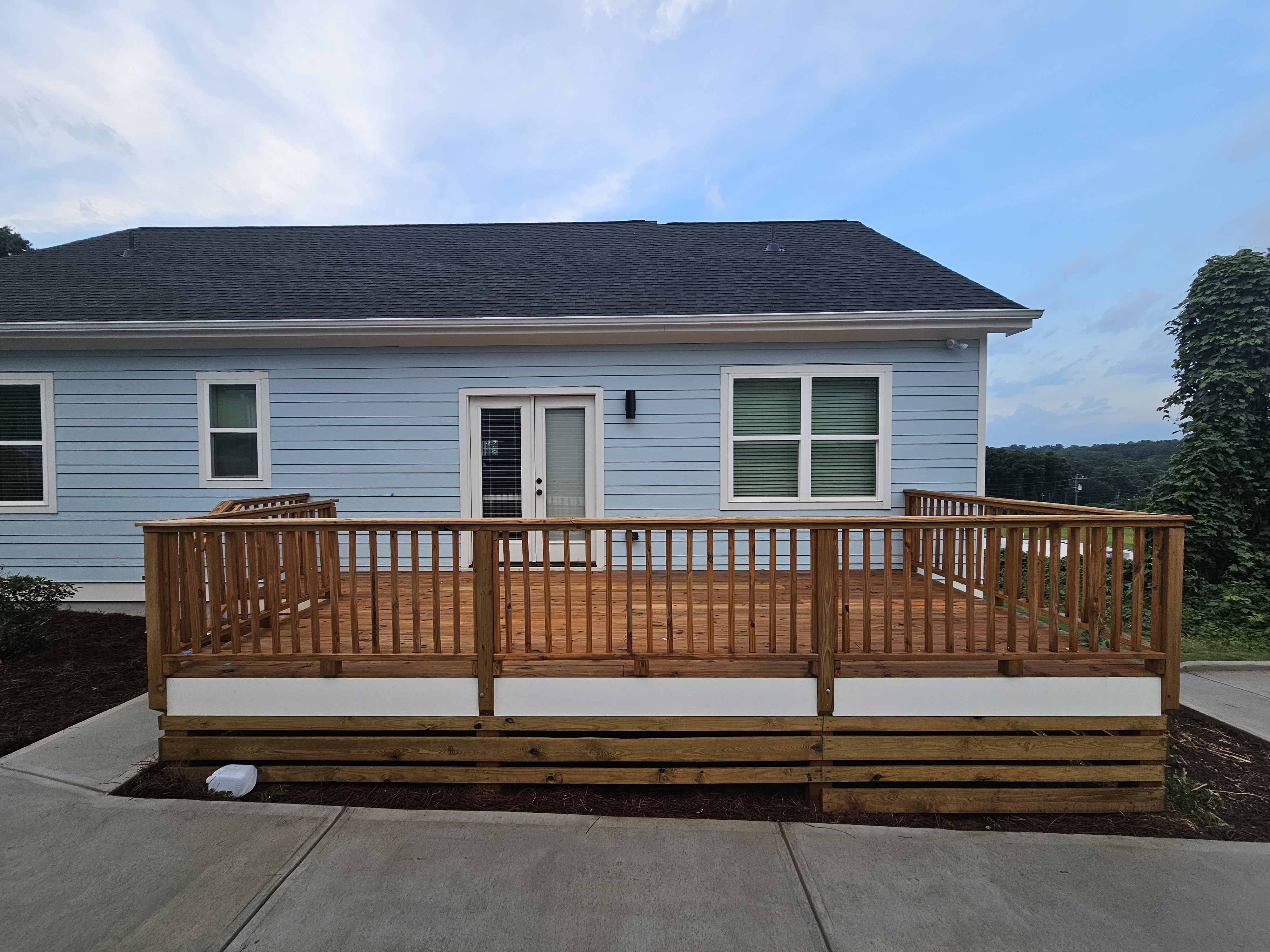 Full rear wood deck with spindle railing on a new construction home at a pressure washing job in Atlanta, GA.
