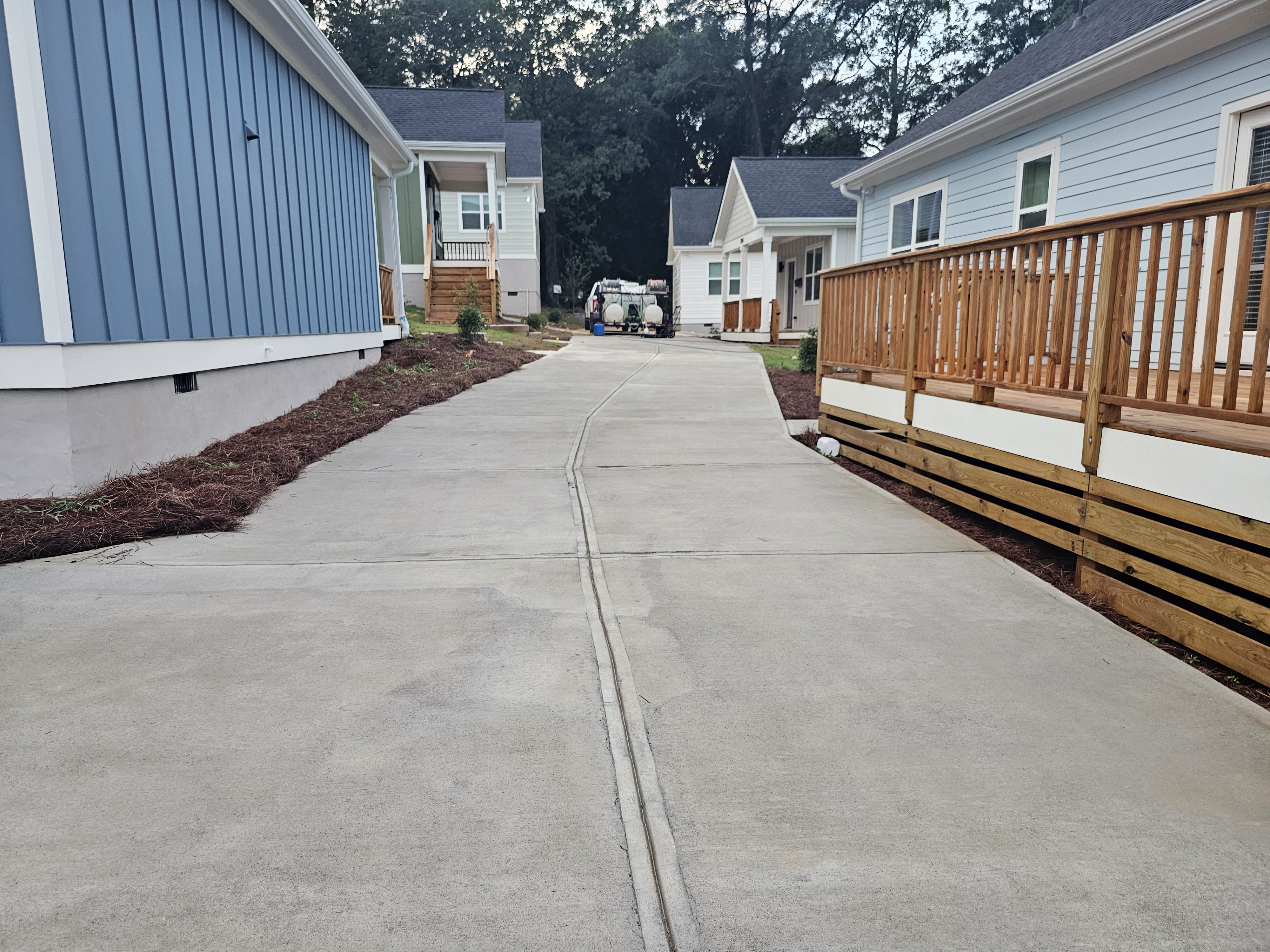 Concrete driveway between multiple new construction homes after pressure washing at a job site in Atlanta, GA.