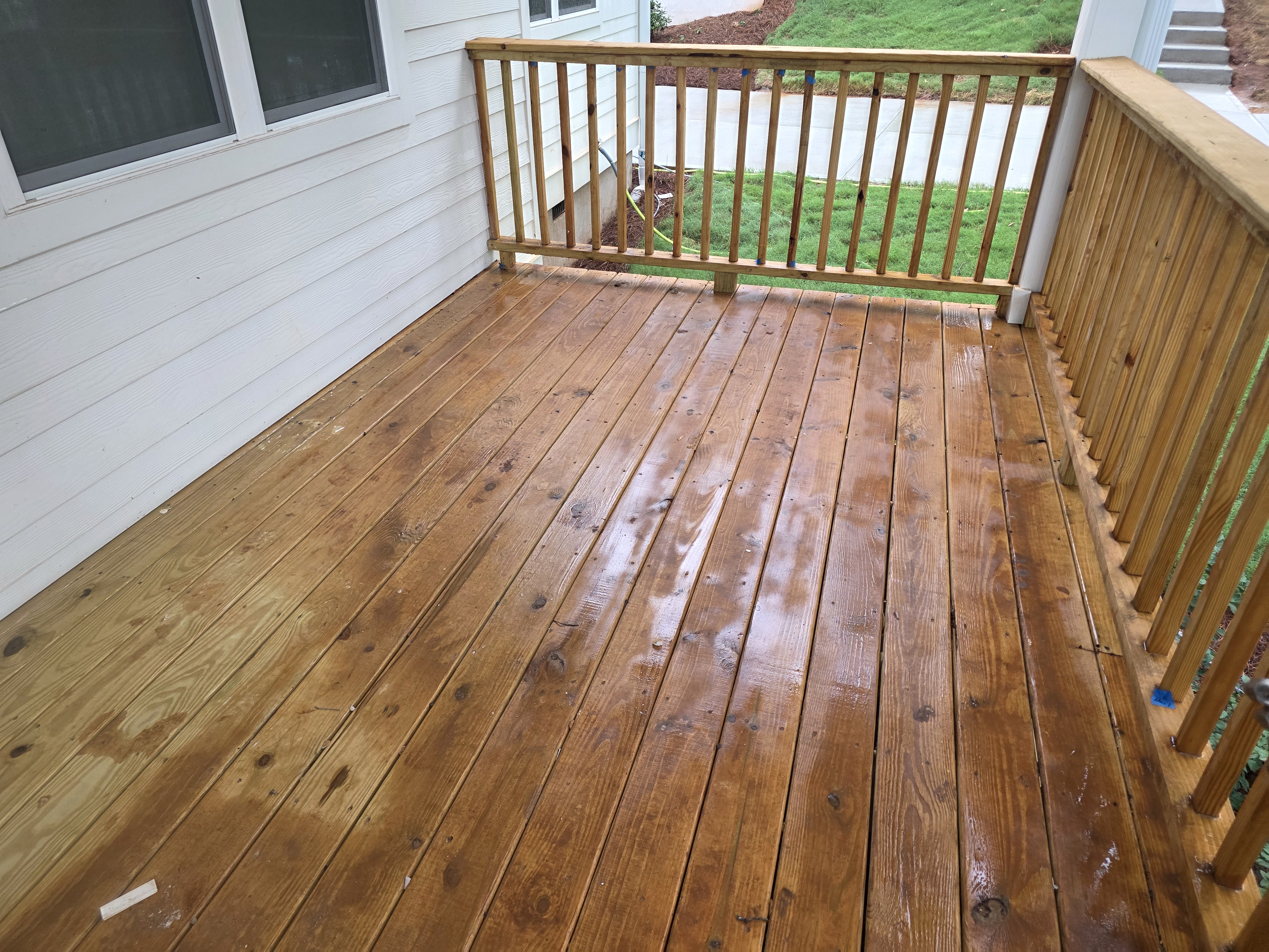 Wide wood deck wet from pressure washing at a new construction home in Atlanta, GA.