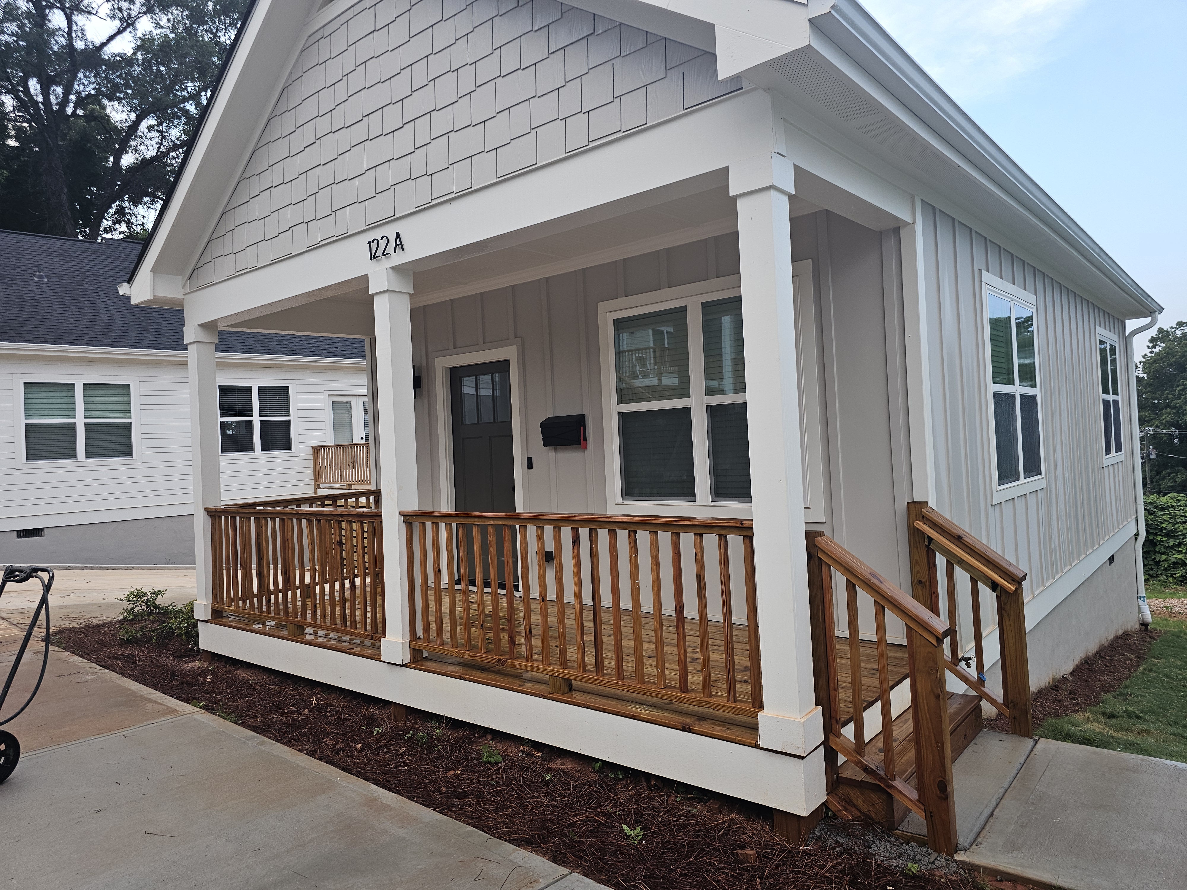 Front porch and wood deck railing on a newly constructed cottage-style home at a pressure washing job in Atlanta, GA.