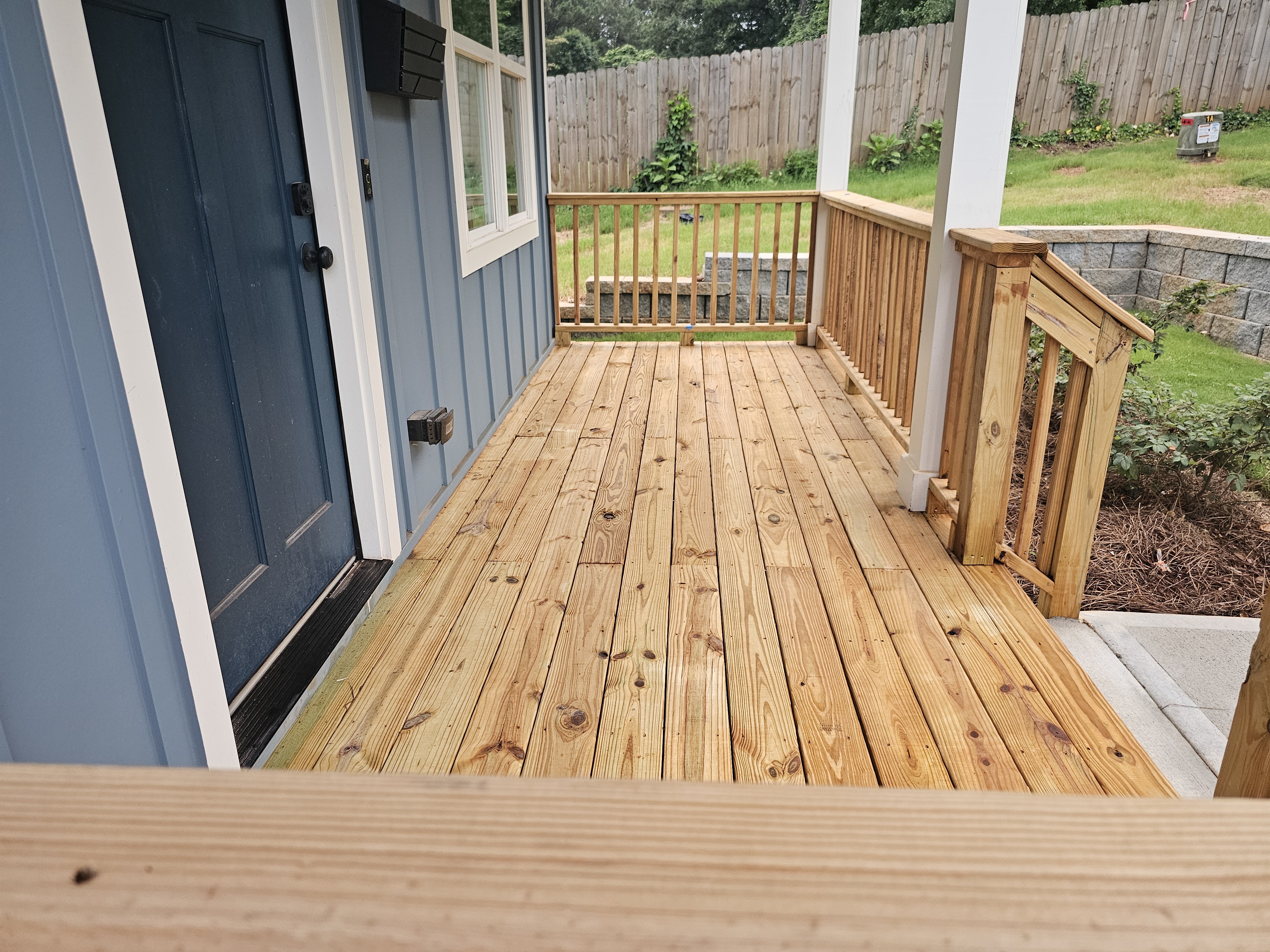 Wood porch deck and spindle railing on a new construction home at a pressure washing job in Atlanta, GA.