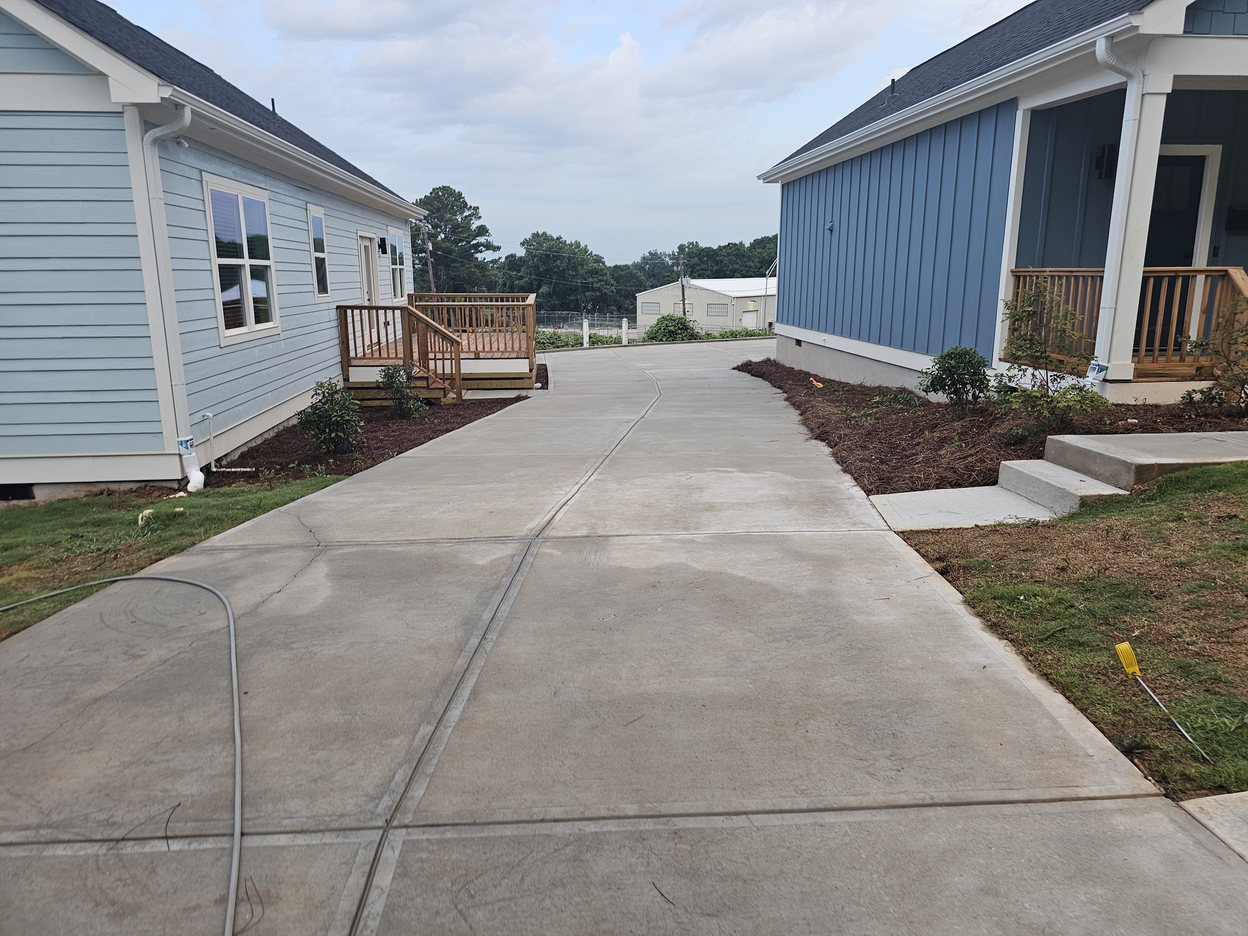 Concrete driveway between two newly constructed homes after pressure washing at a new construction job in Atlanta, GA.