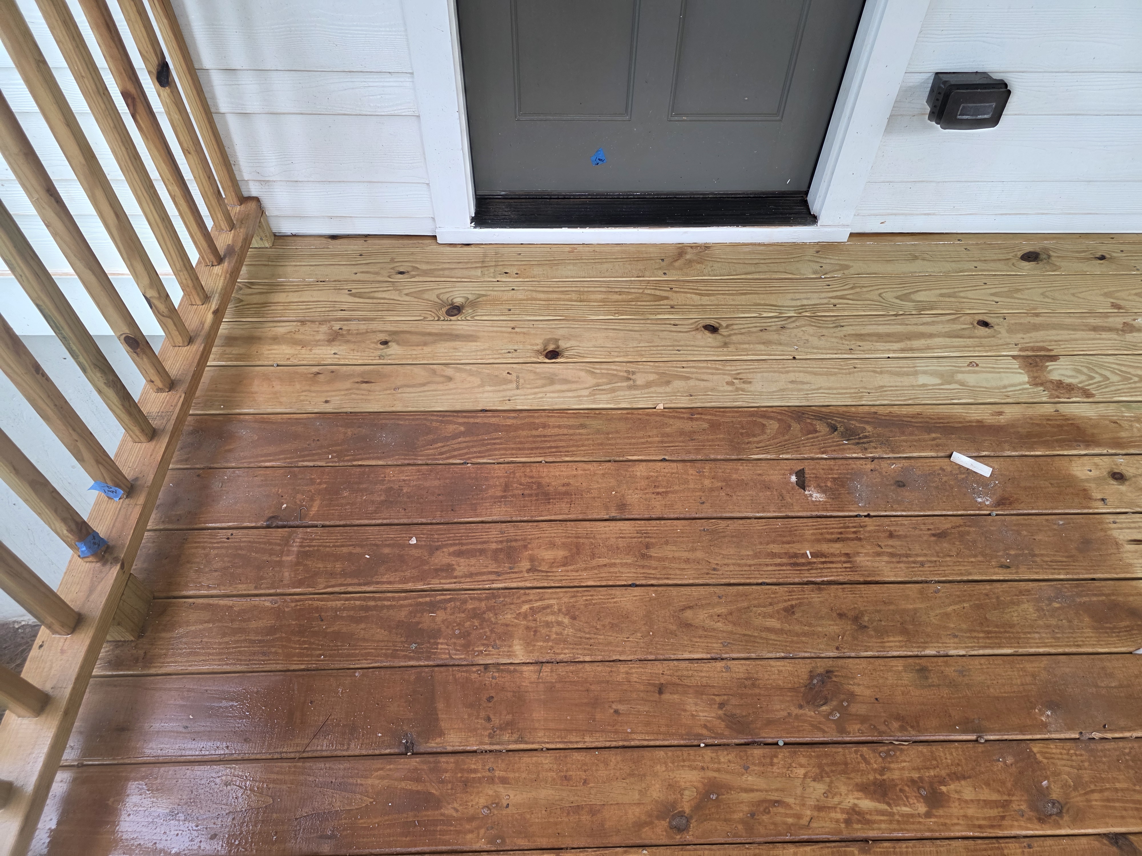 Wood deck boards during pressure washing showing contrast between wet and dry areas at a new construction job in Atlanta, GA.