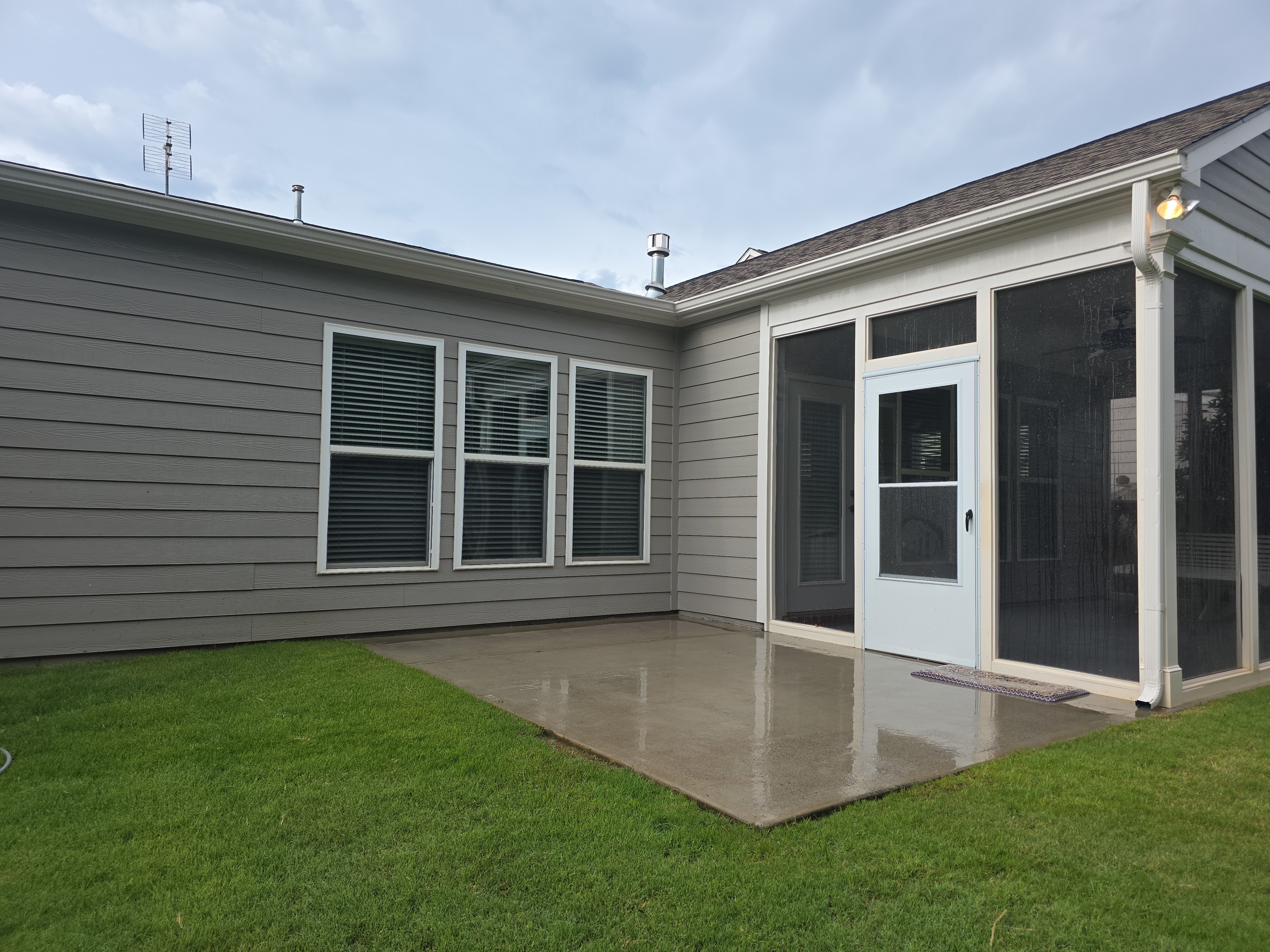 Concrete back patio and screened porch after pressure washing in Woodstock, GA — clean surface and siding ready for home listing