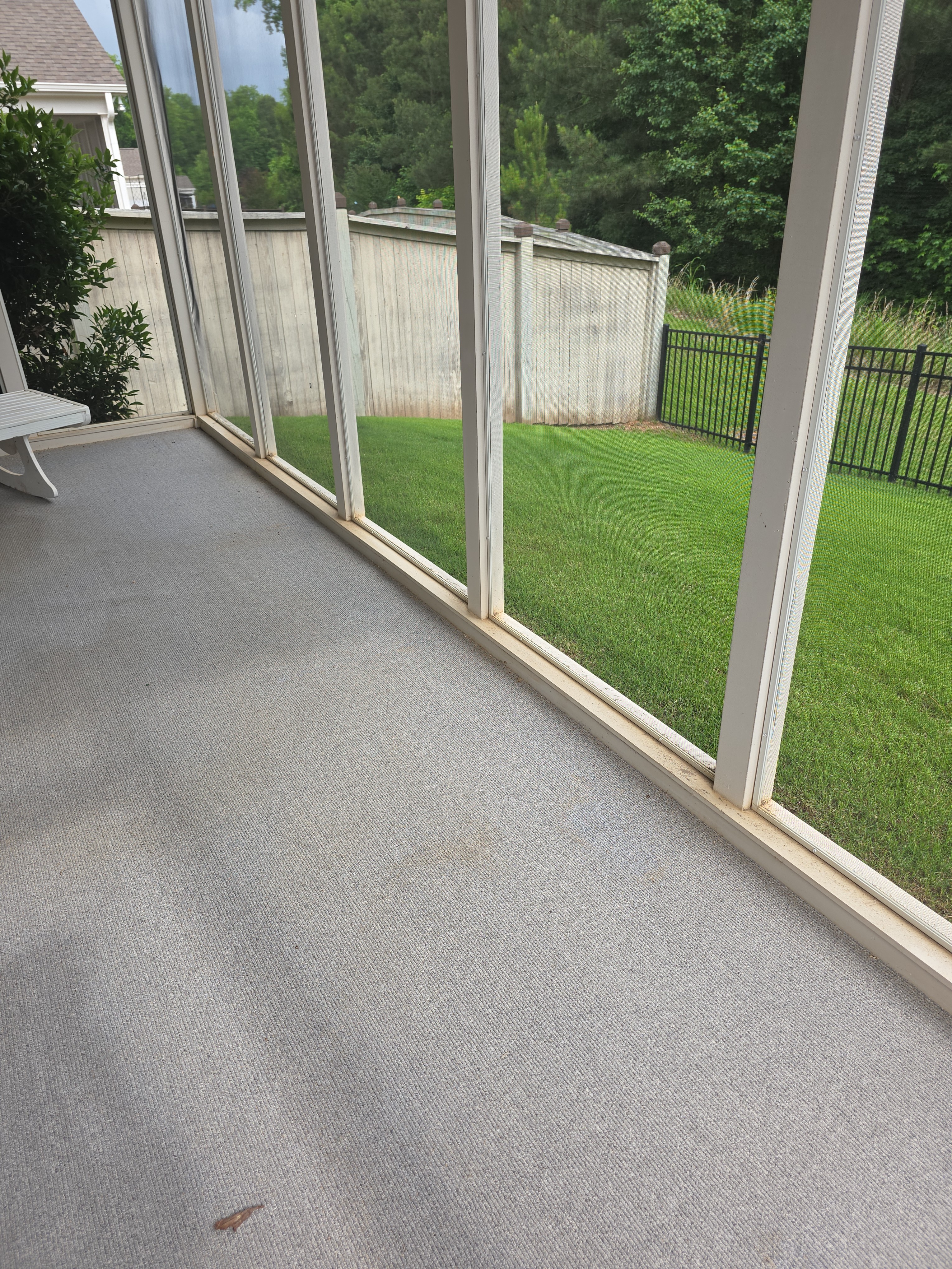 Interior floor of screened porch before cleaning in Woodstock, GA, showing surface staining and grime along base frames