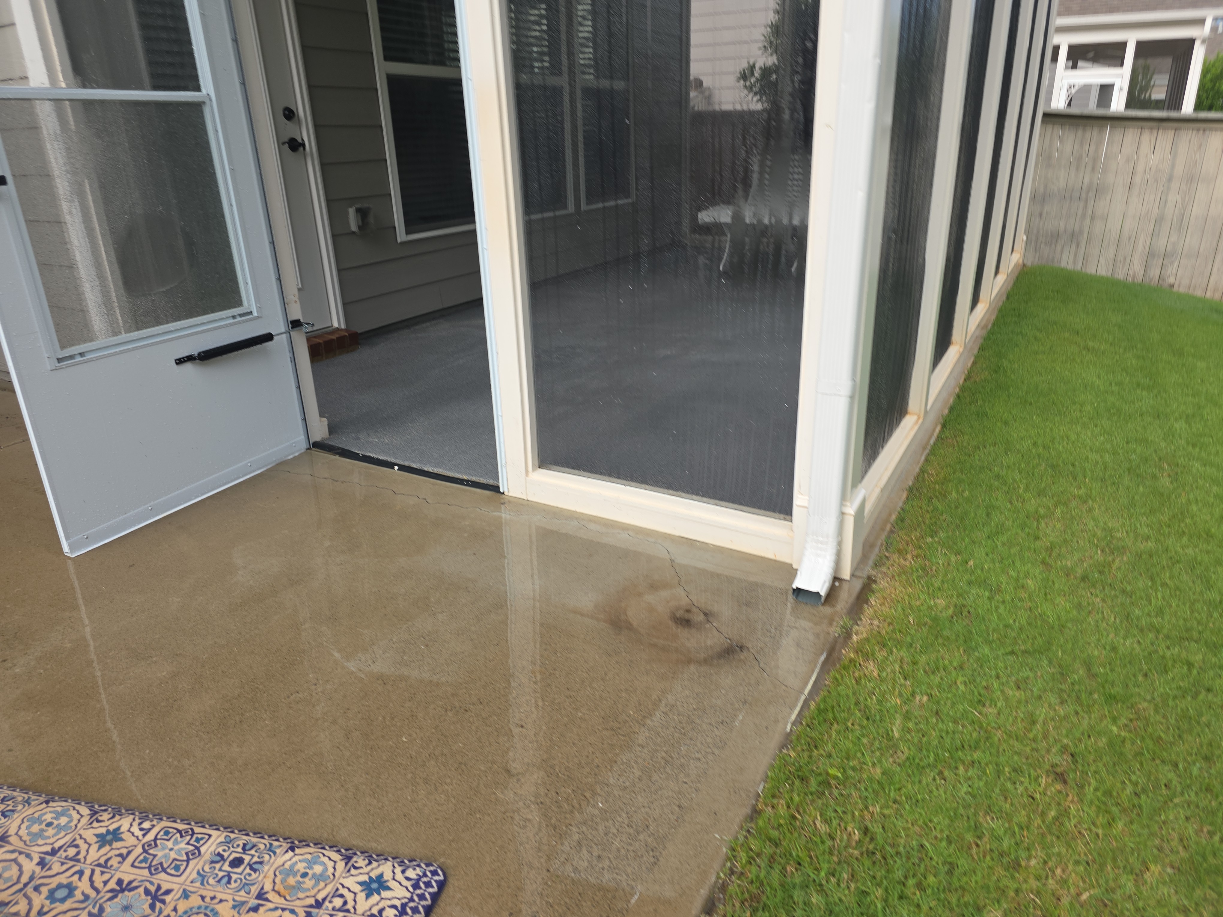 Freshly pressure-washed concrete patio next to screened porch in Woodstock, GA, surface clean and still wet after service