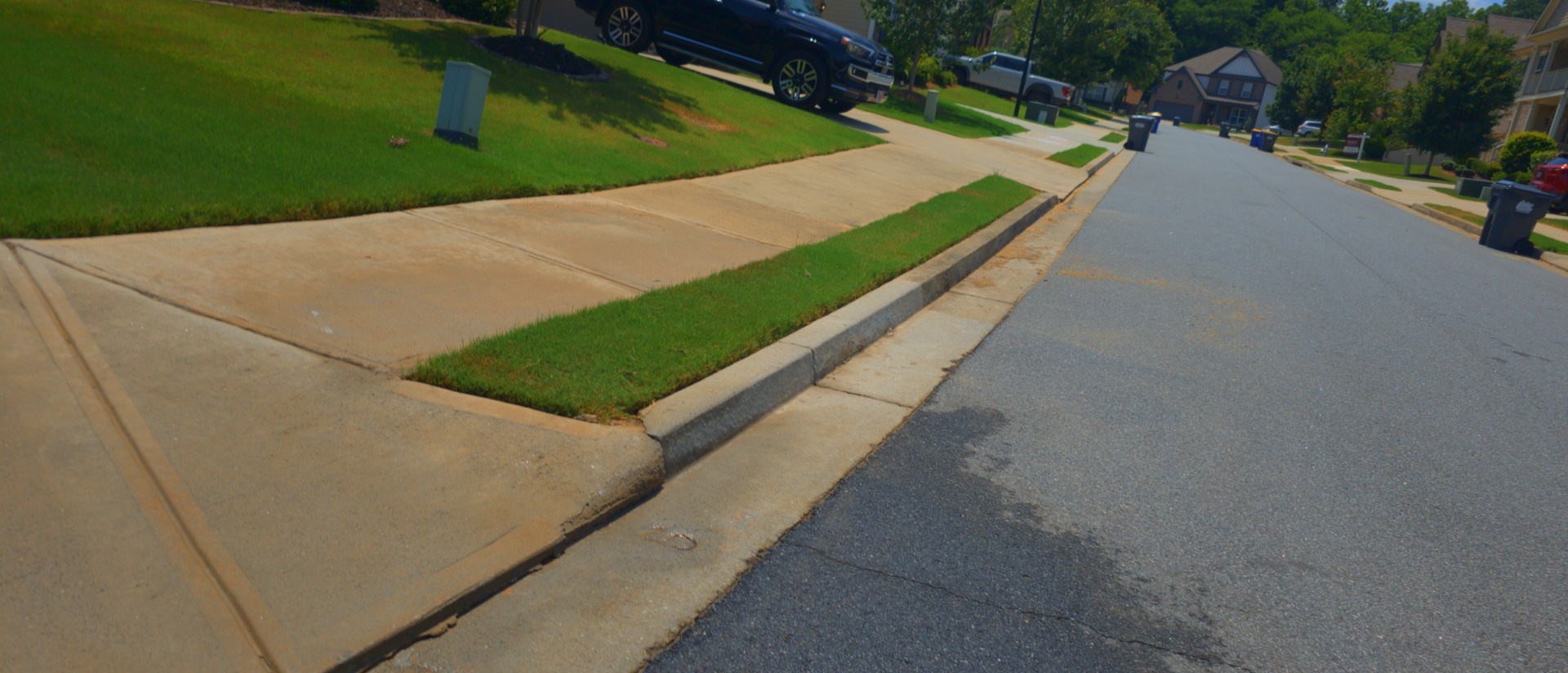 Concrete driveway apron and sidewalk at a residential home in Canton, GA after pressure washing.