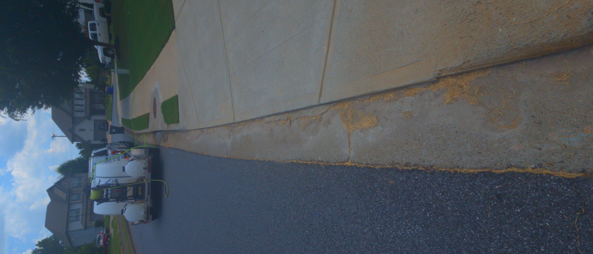 Concrete curb and sidewalk with rust and dirt staining at a pressure washing job in Canton, GA.