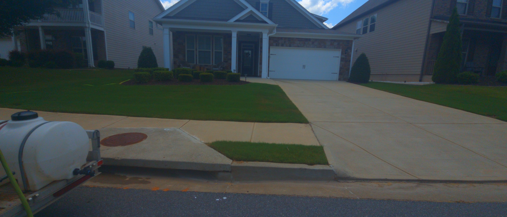Alpha Pressure Washing equipment set up in front of a residential driveway during a concrete cleaning job in Canton, GA.