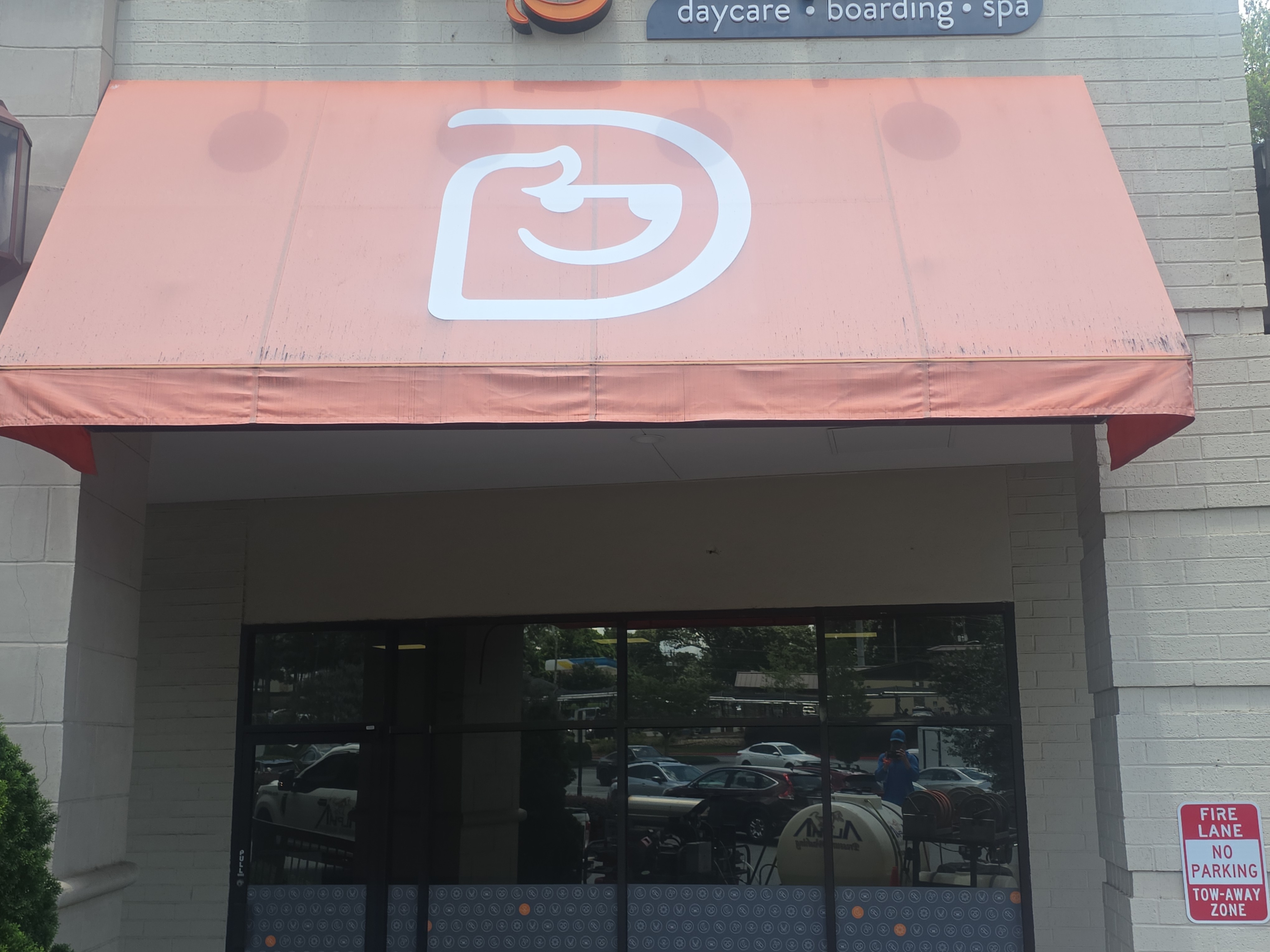 Close-up of a commercial fabric awning at a pressure washing job in Roswell, GA, showing the surface texture and logo graphic.
