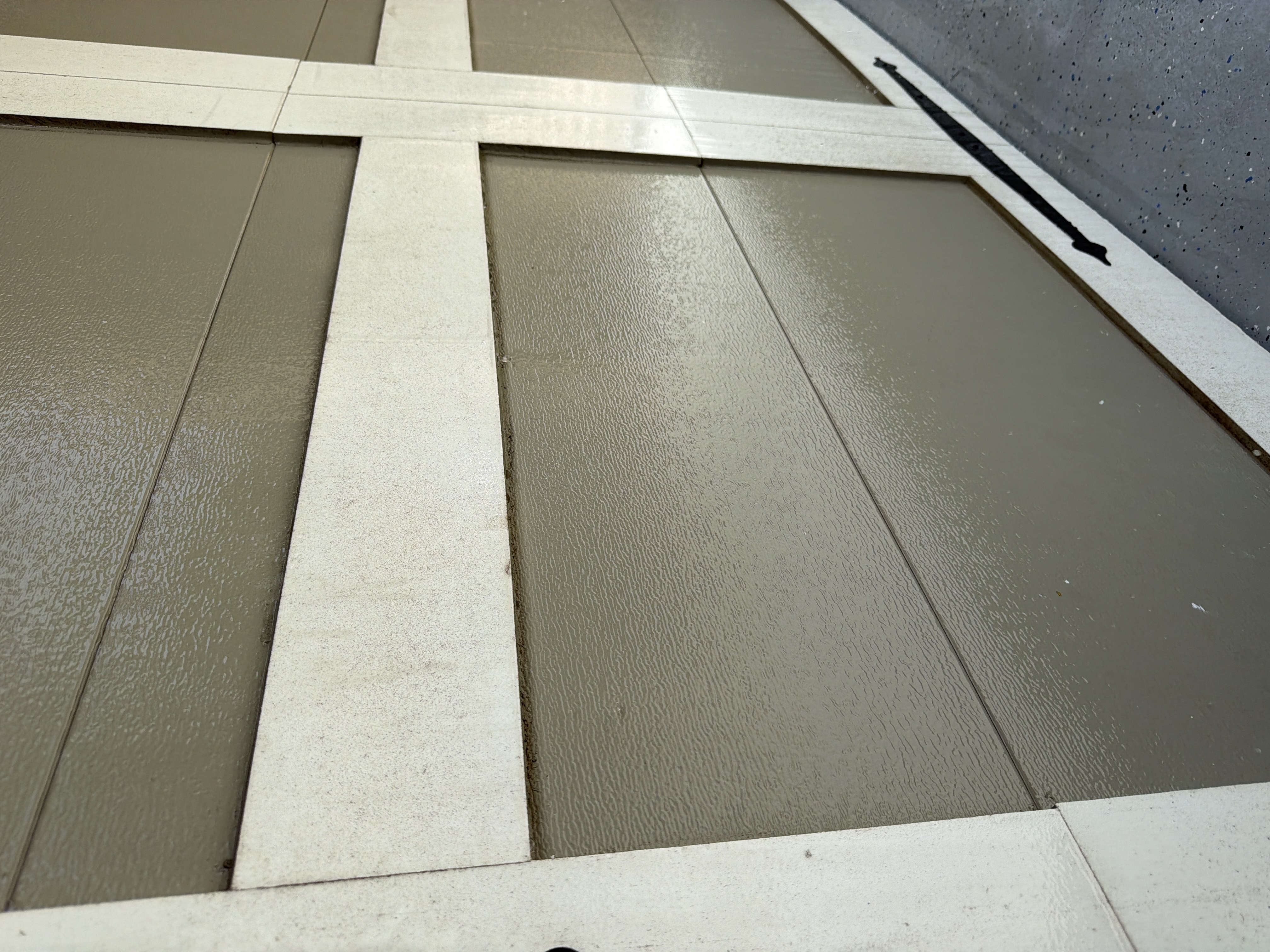 Yellow-green sheen on the paintwork of the garage door.