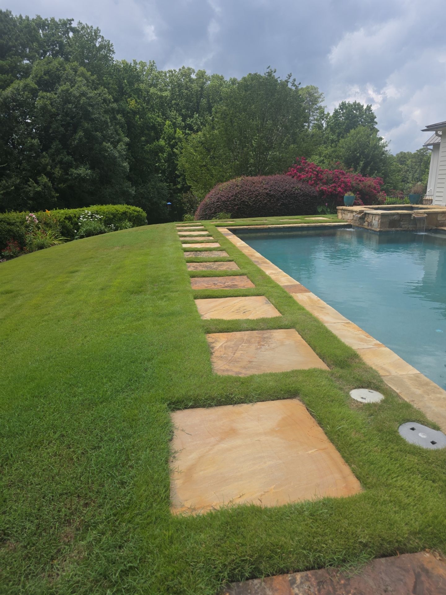 Stone stepping-pad pathway beside a residential pool at a pressure washing job in Milton, GA.