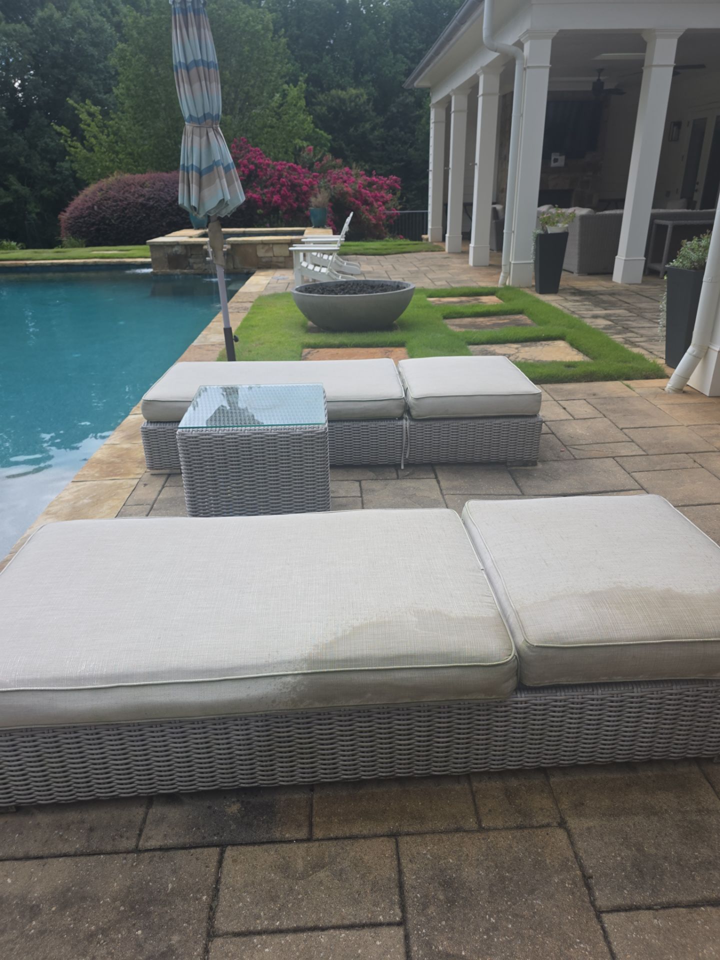 Wicker chaise lounges on a stone pool deck at a residential backyard in Milton, GA.