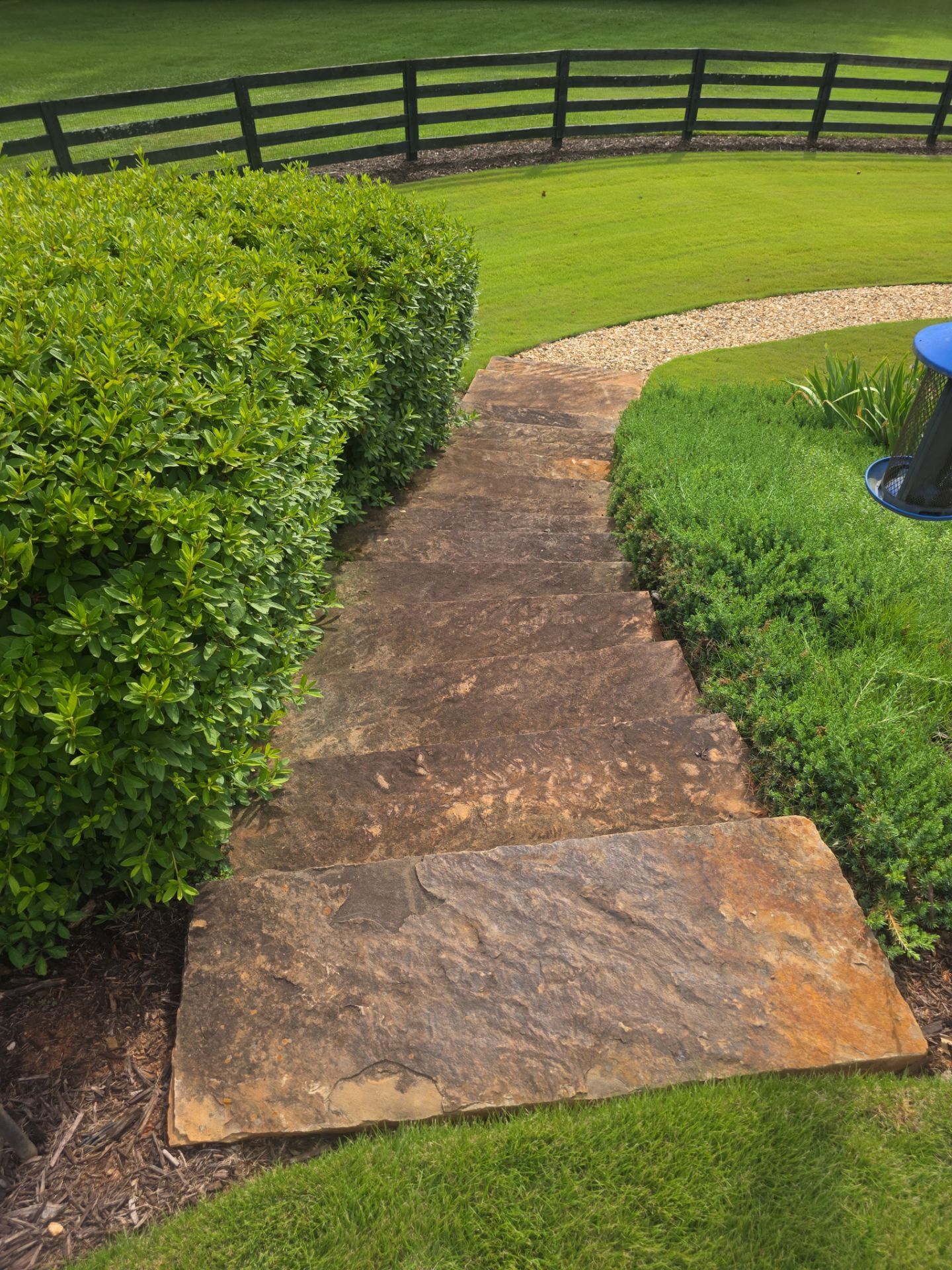 Flagstone garden path flanked by hedges and lawn at a residential property in Milton, GA.
