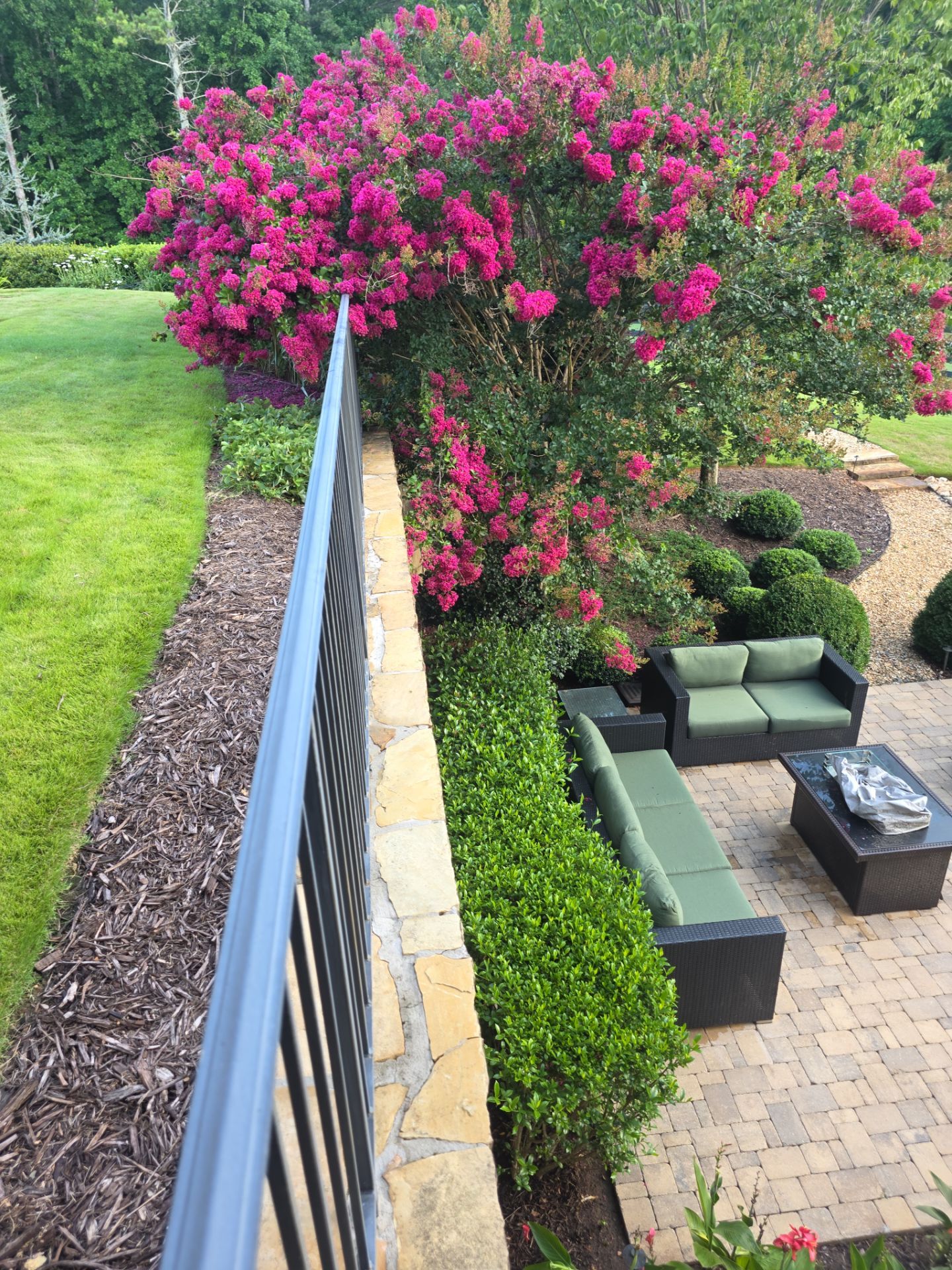 Overhead view of a brick-paver patio with outdoor seating and blooming crape myrtle at a Milton, GA home.