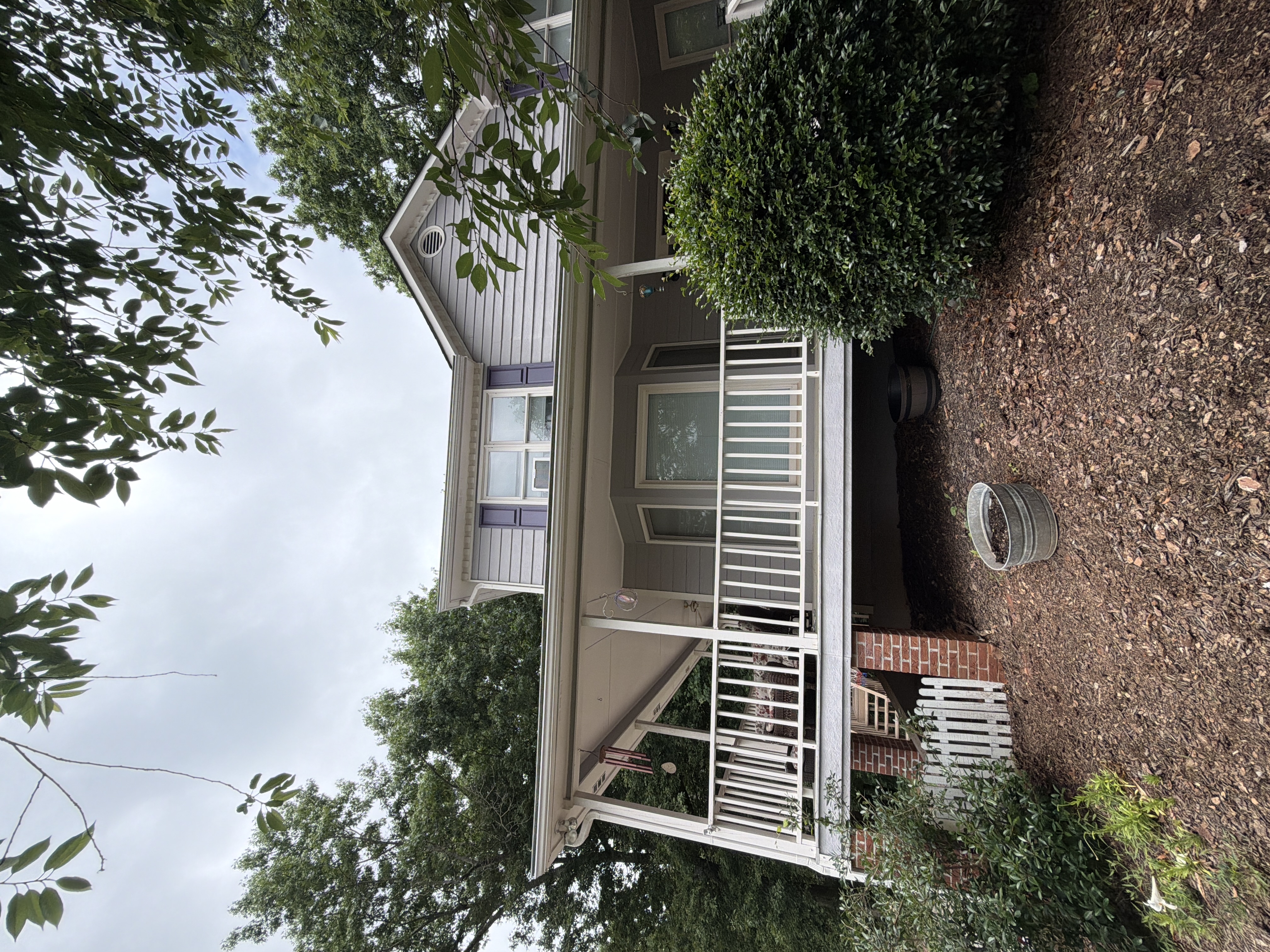 Rear exterior of two-story Canton, GA home showing clean vinyl siding and covered porch after house washing service